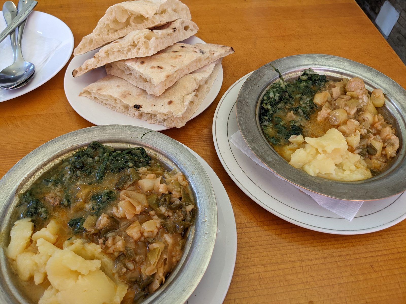 beans and mash two metal bowls are filled with Bosnian baked beans, mashed potato and greens