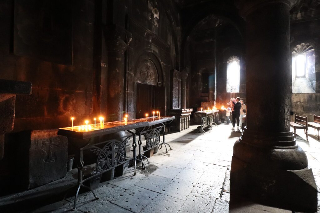 inside of UNESCO Geghard Monastery lit with candles