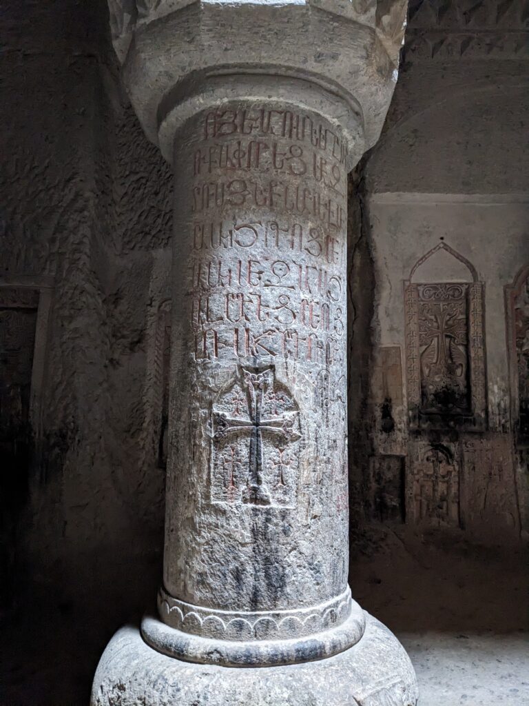 ancient armenian inscriptions on a pillar in UENSCO Geghard monastery