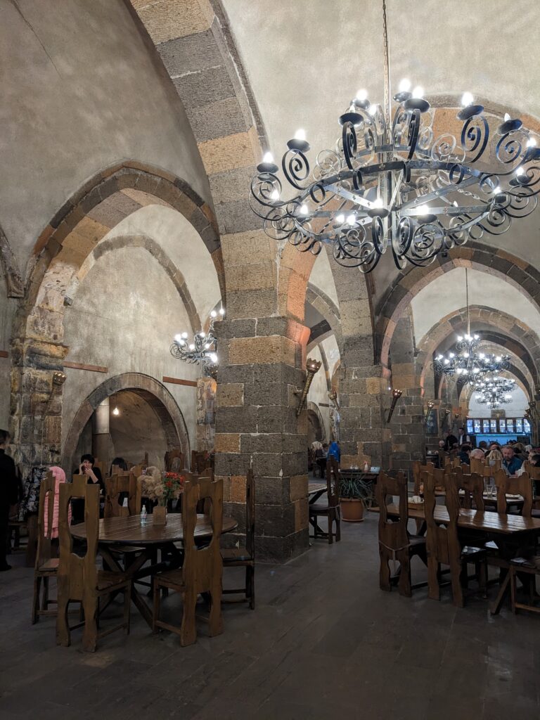 the inside of historic agape refectory with high ceilings and medieval hanging decoration