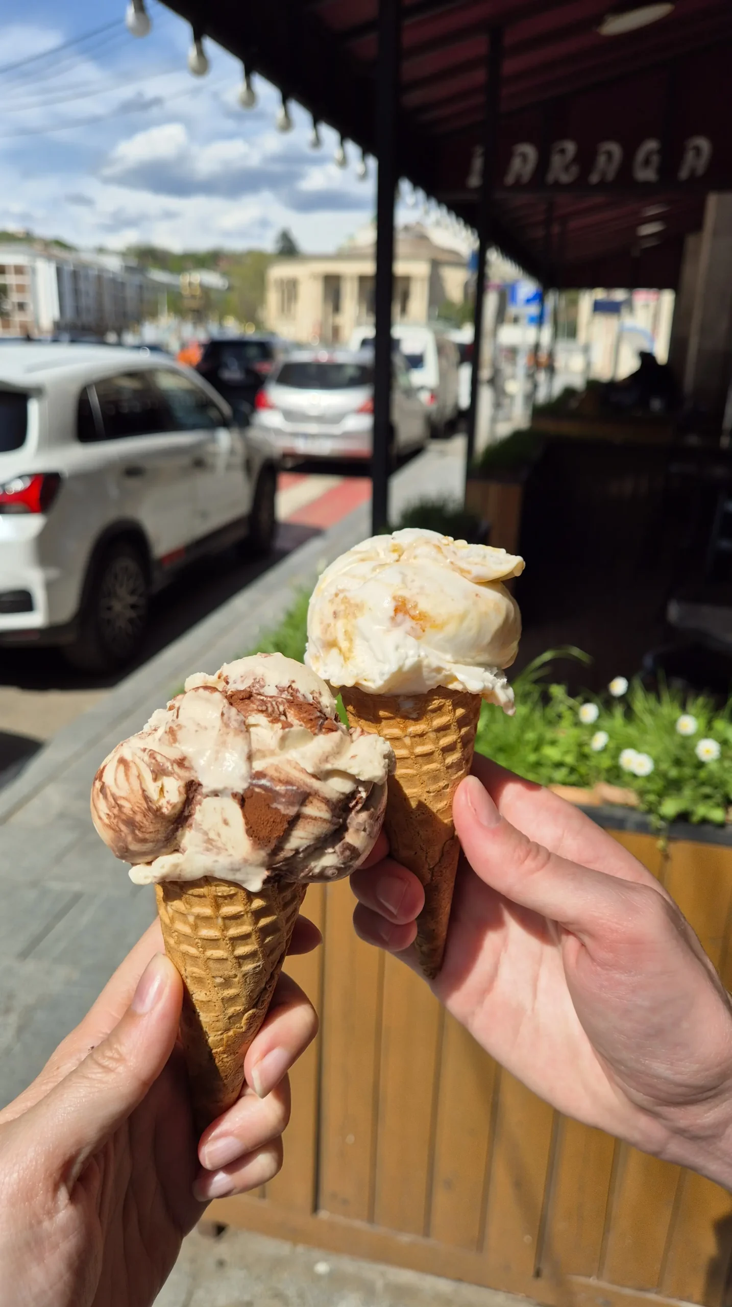 Mio ice cream Two ice cream cones - one has a tiramisu ice cream, the other has an orange cheesecake ice cream
