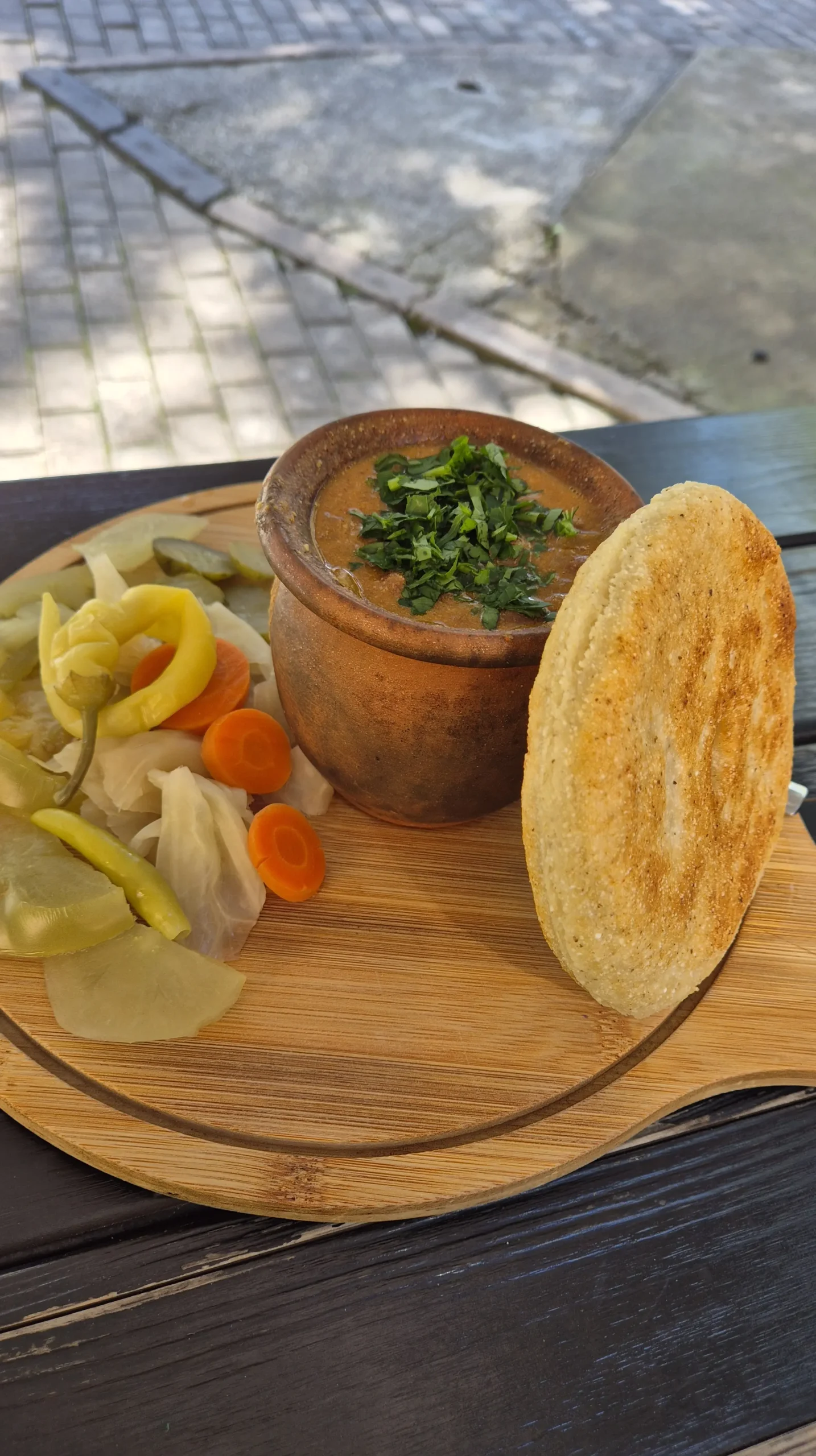 lobio from Fleur a clay pot full of lobio (Georgian bean stew) on a wooden board of pickles and cornbread