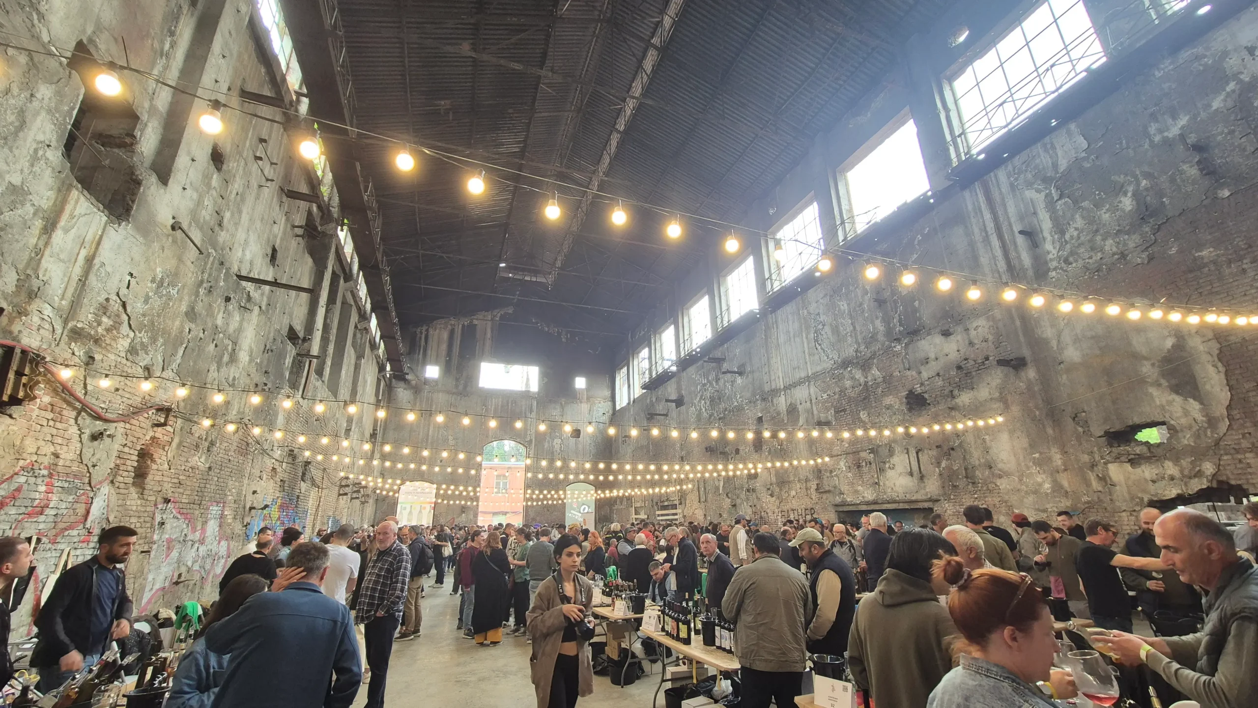 Natural Wine Festival the gutted interior of a Soviet radio factory has stands for wine tastings, fairy lights, and high ceilings at Tbilisi' Natural Wine Festival
