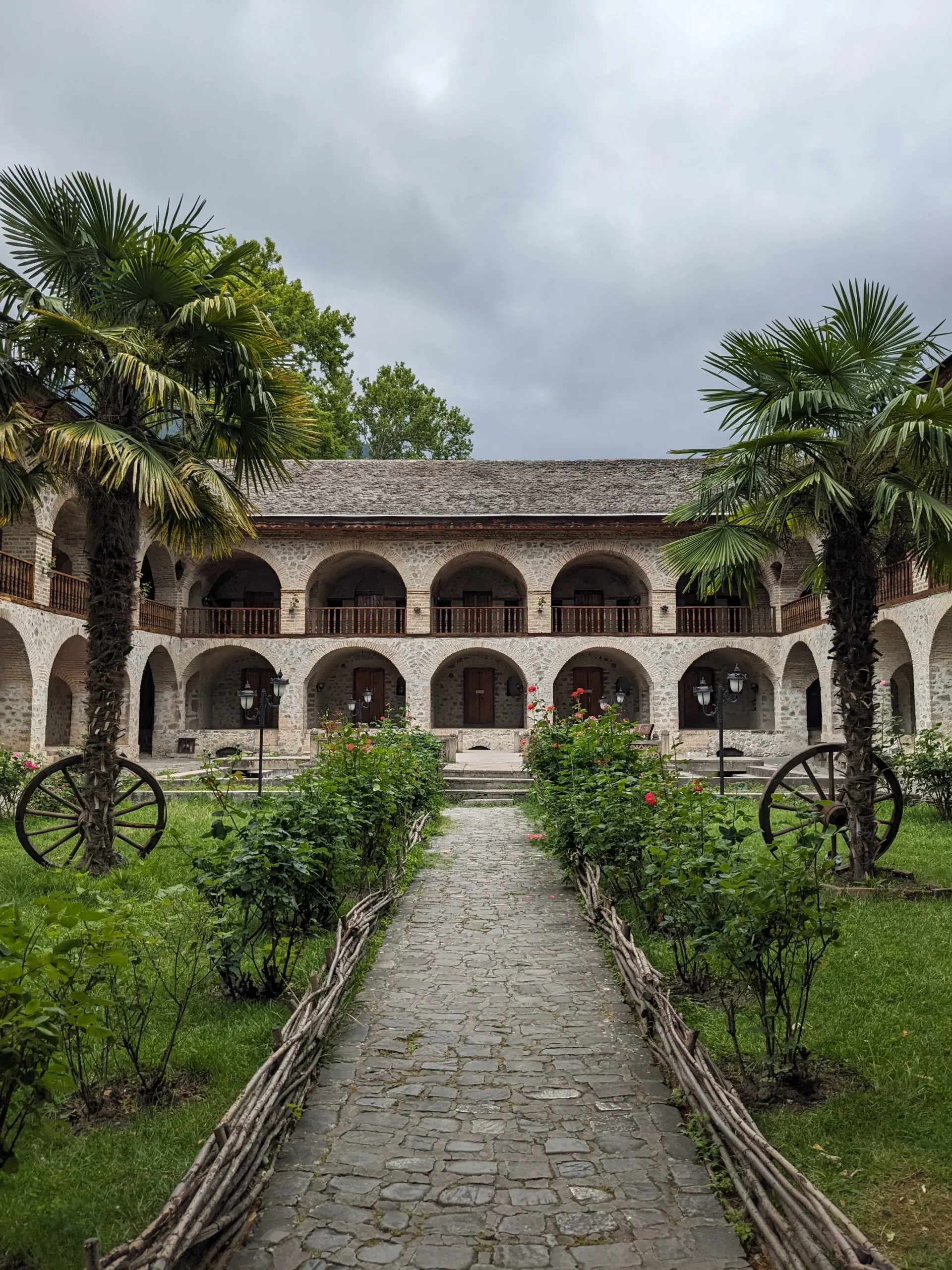 the interior of a traditional caravanserai in Sheki Azerbaijan with domed archways and palm trees