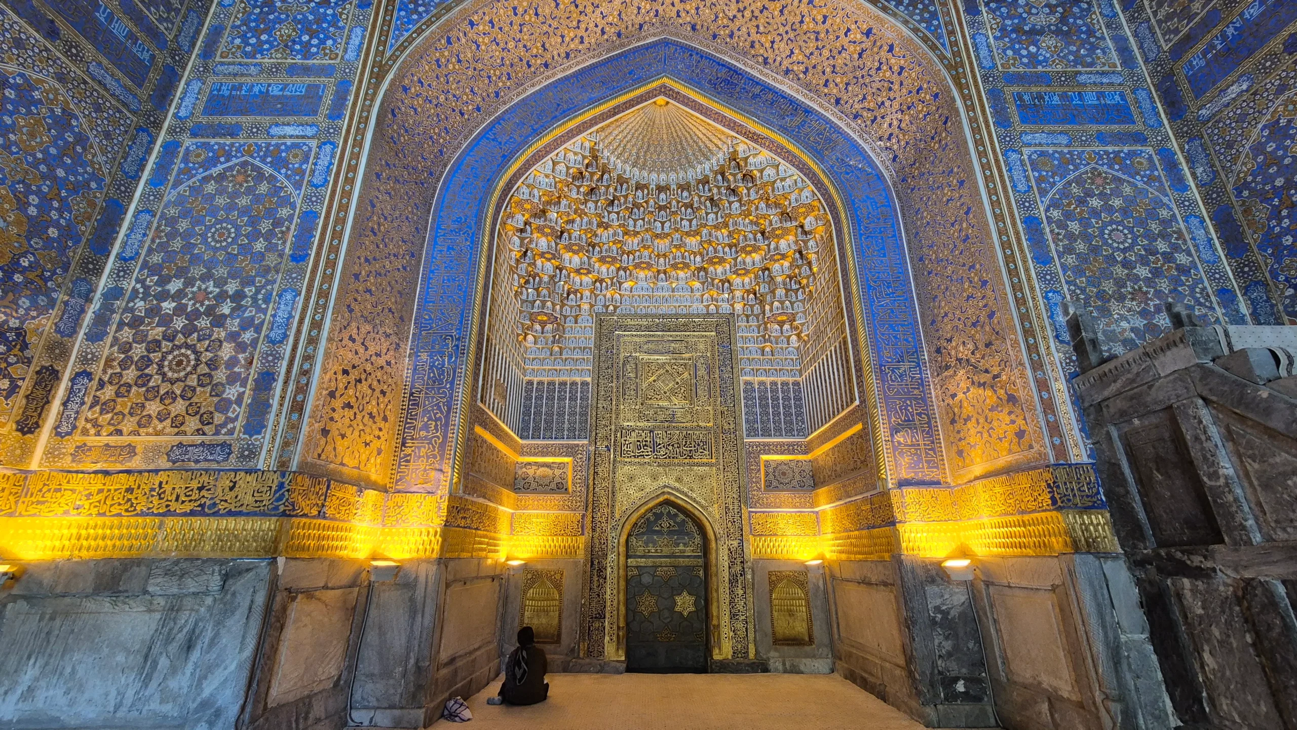 Registan, Samarkand a decorative archway in a mosque has intricate blue and gold geometric tiling in Registan, Samarkand, Uzbekistan