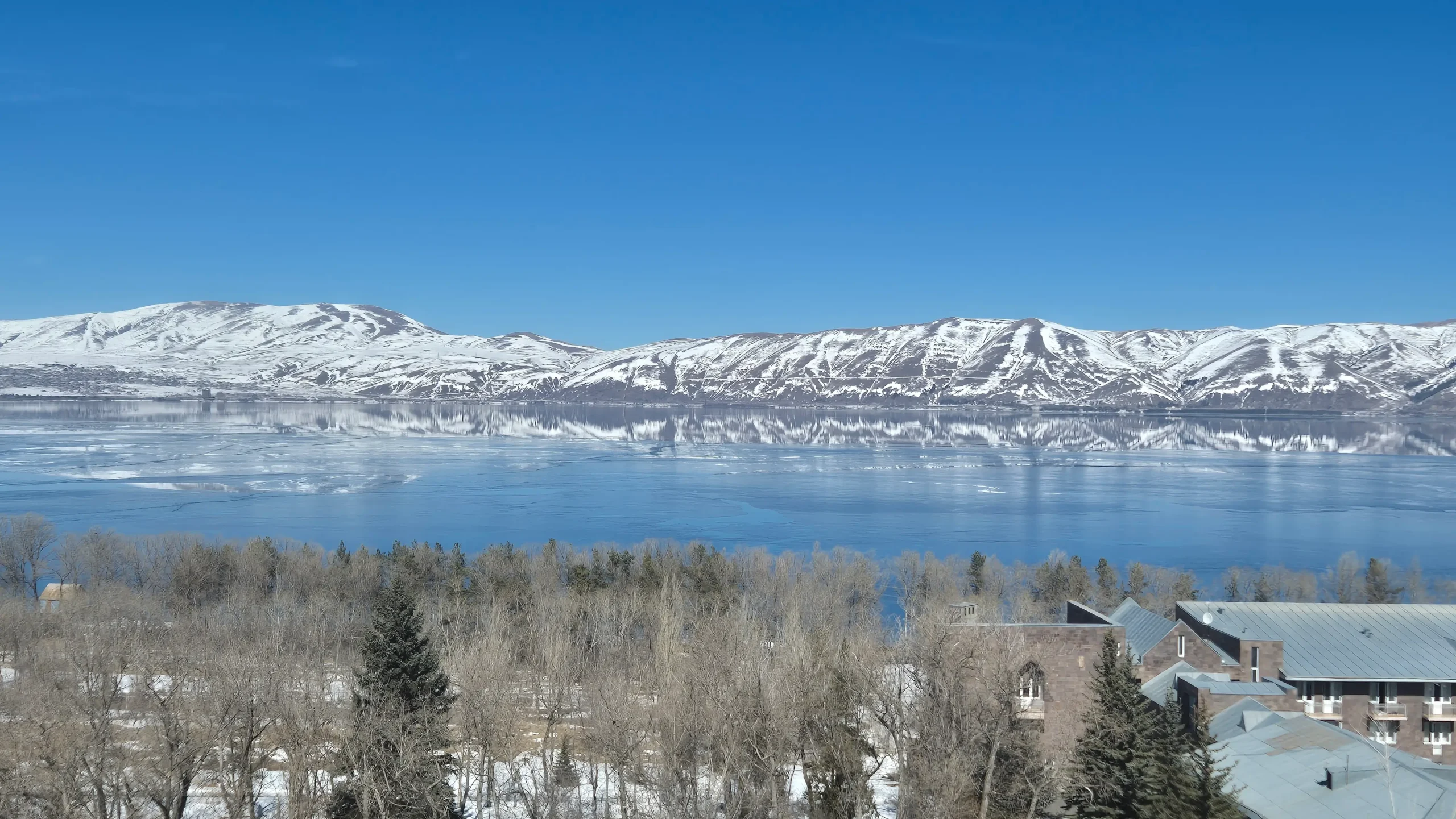 snow covered hills surround the still waters of Lake Sevan in Armenia