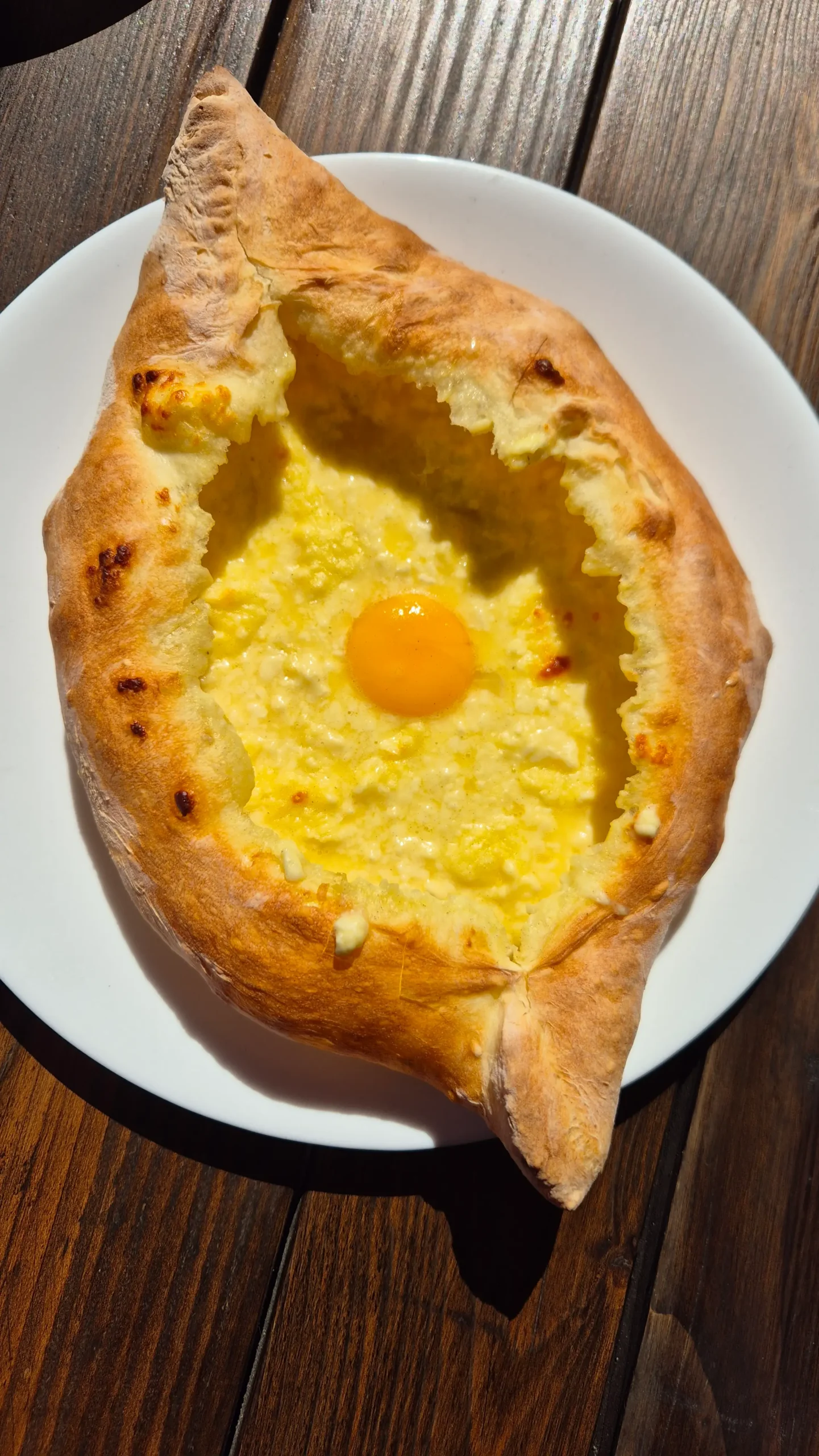 Acharuli Khachapuri House Acharuli Khachapuri House - a bread boat filled with melted cheese and a runny egg yolk