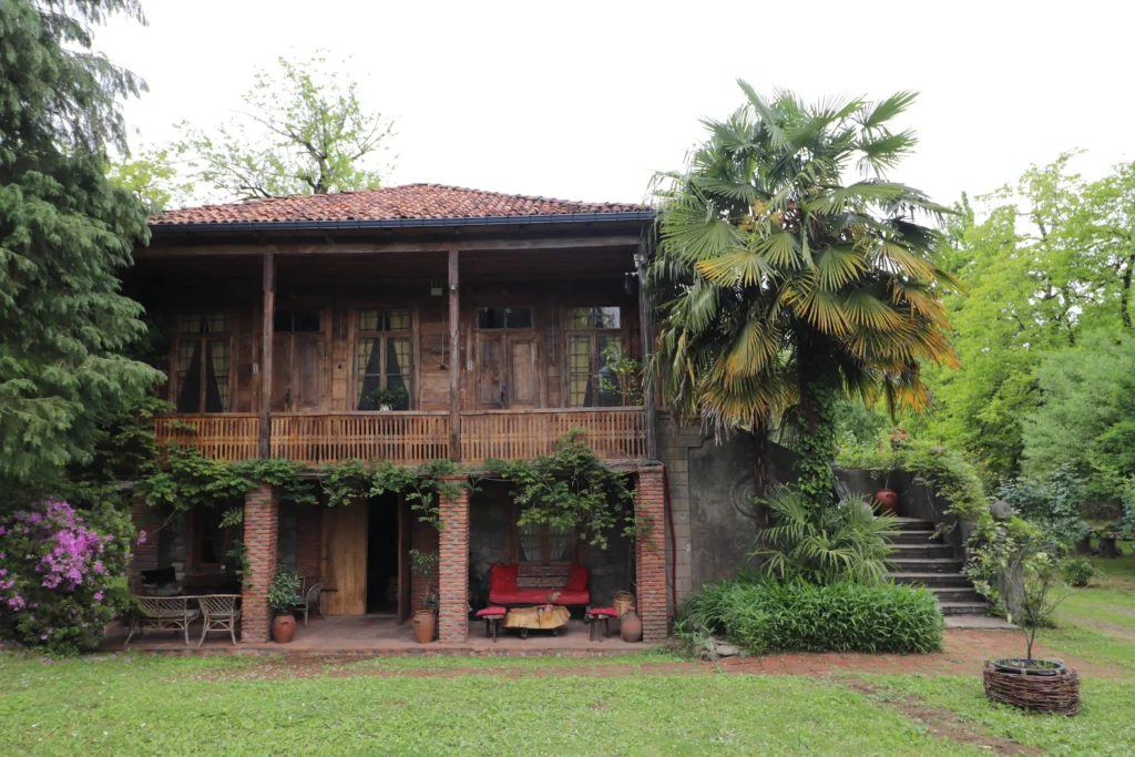 Menabde Winery, Ozurgeti a traditional wooden oda house in Guria, Georgia, surrounded by tropical plants