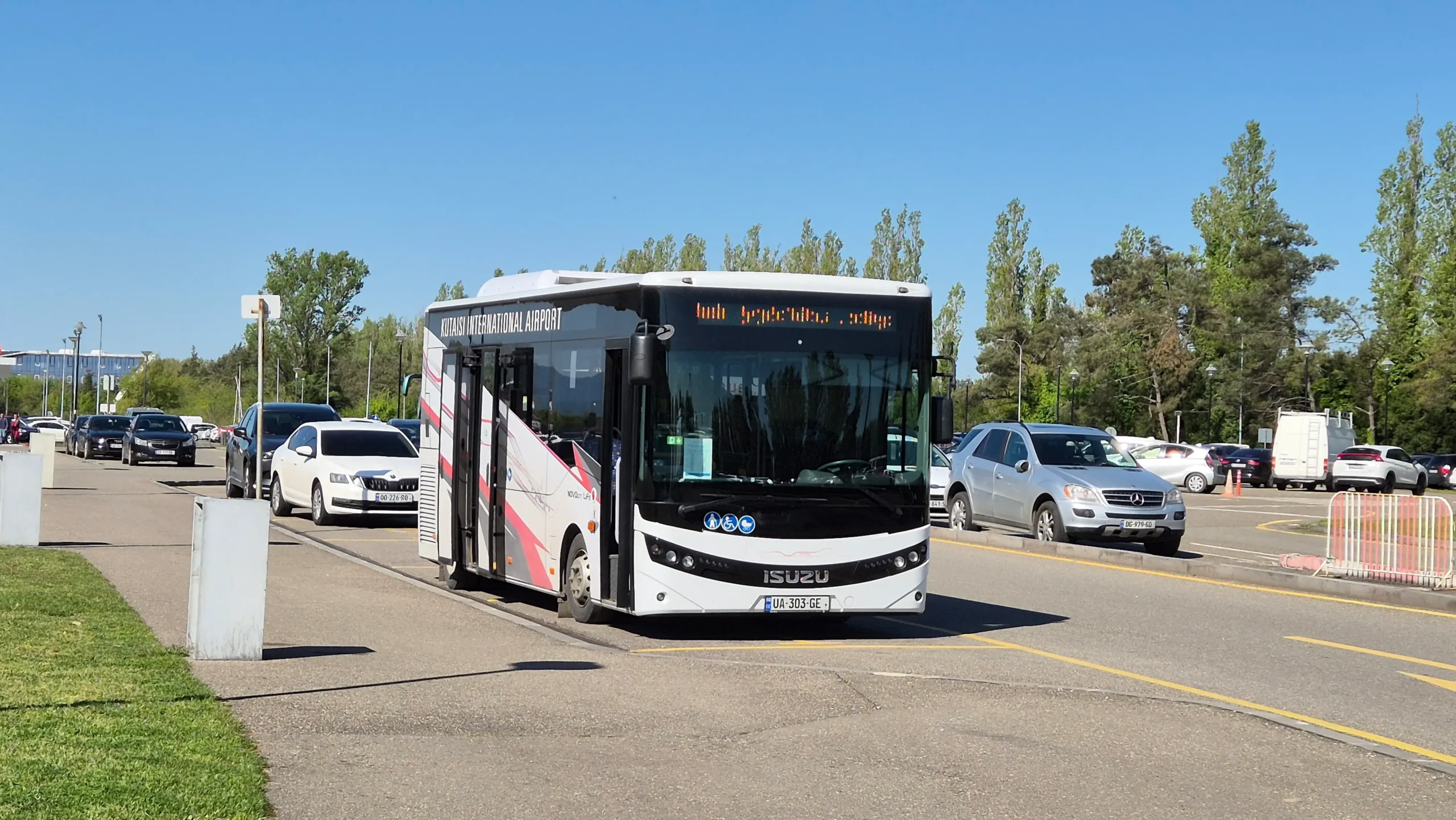Kutaisi airport shuttle a red and white public bus is parked at the side of the road - Kutaisi airport shuttle bus