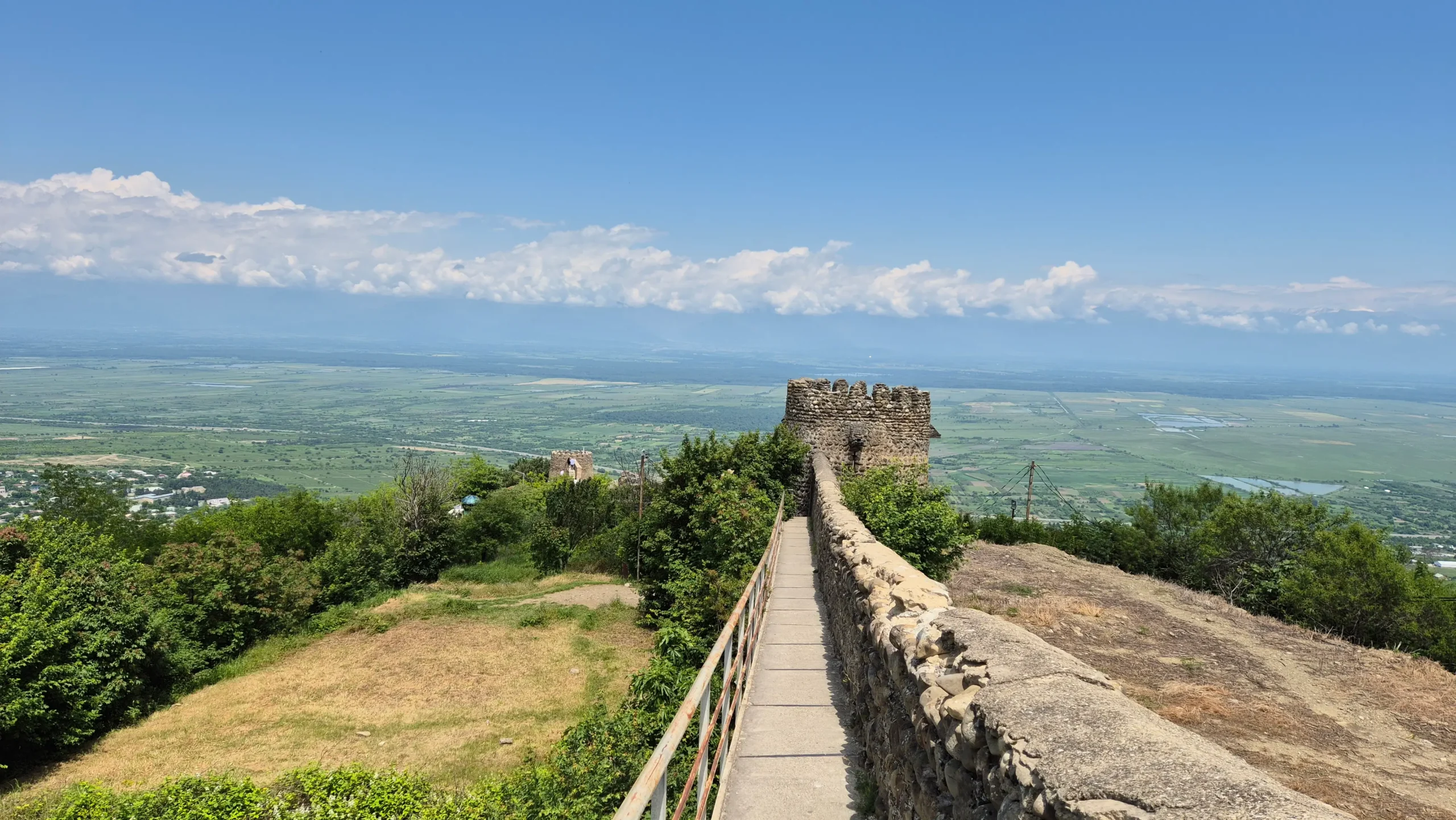 Sighnaghi Fortress Walls a pathway along the historic fortress walls leads to a brick turret overlooking endless green plains and a blue sky in Sighnaghi, Telavi