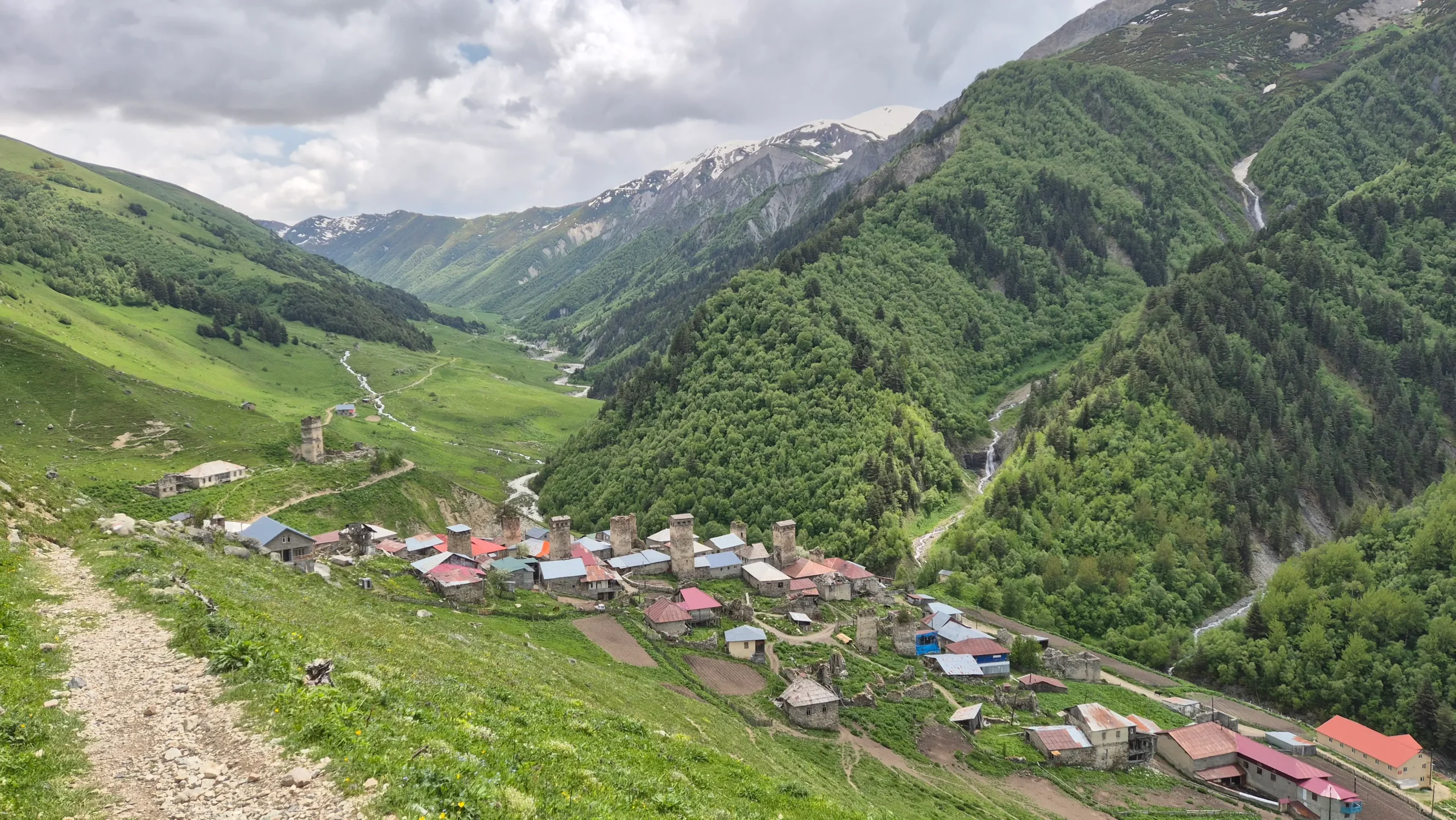 Adishi village Adishi village with brick watchtowers and red and grey rooftops sits in a lush valley in Svaneti, Georgia
