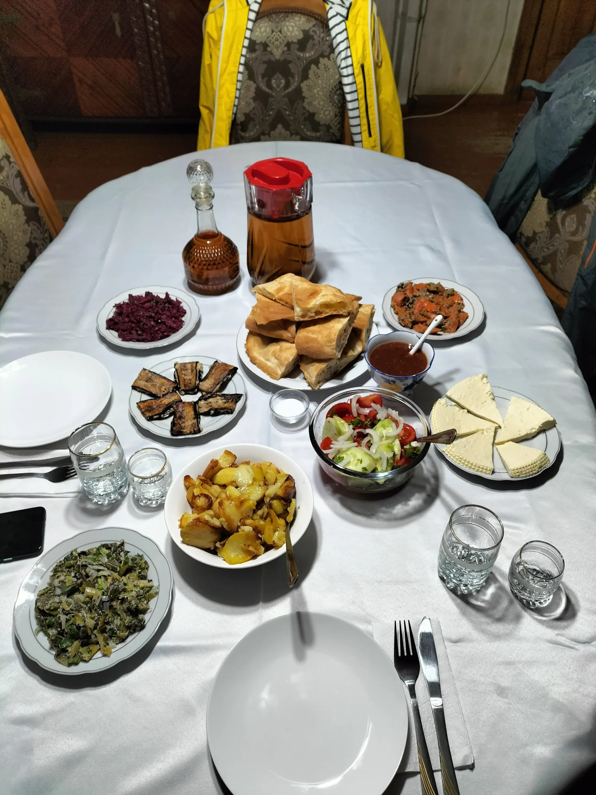 a Georgian dinner spread of bread, aubergine, potatoes, salad, cheese, wine, and chacha - Lunch at Lia, Chiatura