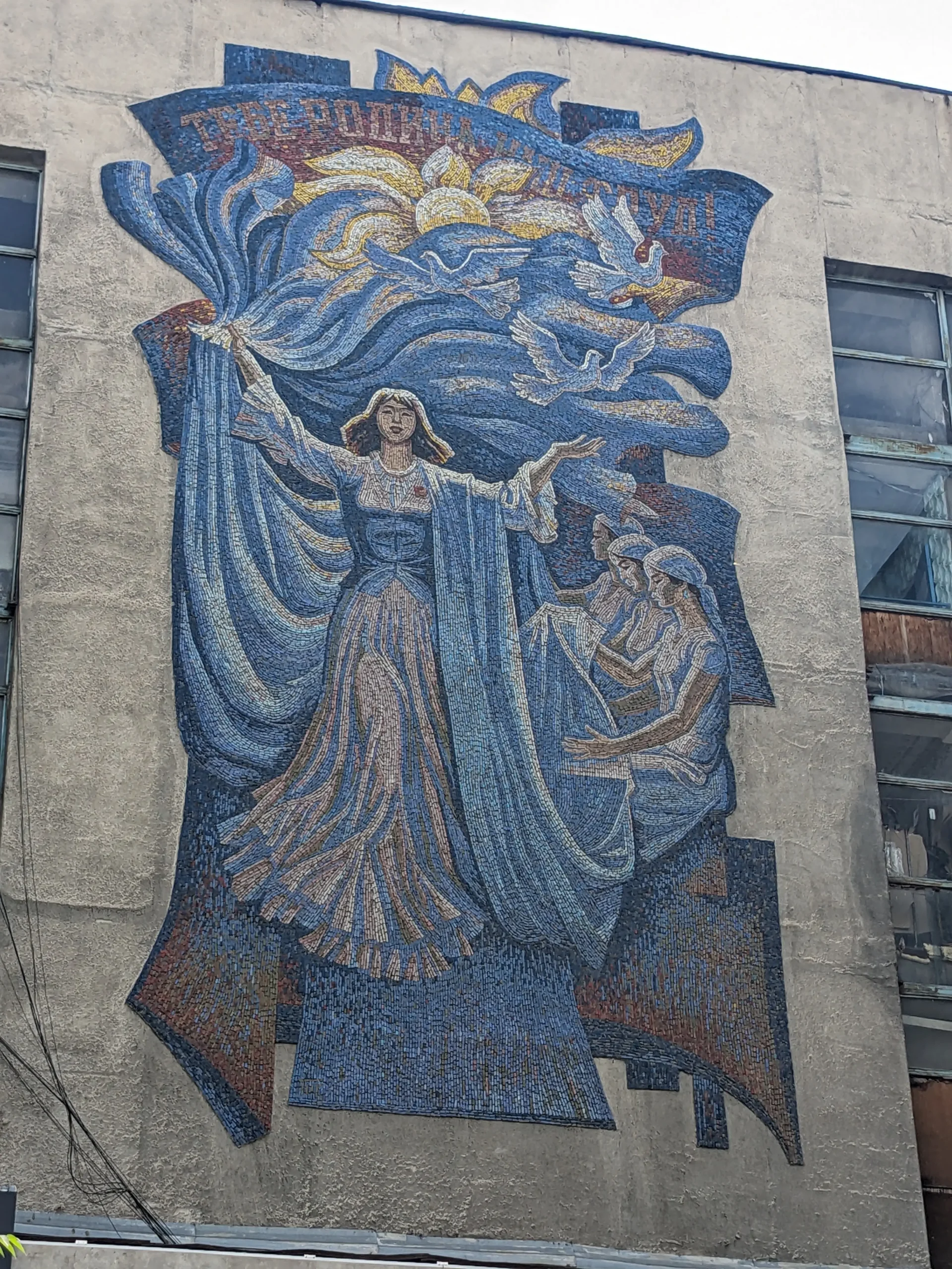 Our Work to You, Motherland A Soviet mosaic depicts women working, doves, and the sun in Bishkek, Kyrgyzstan