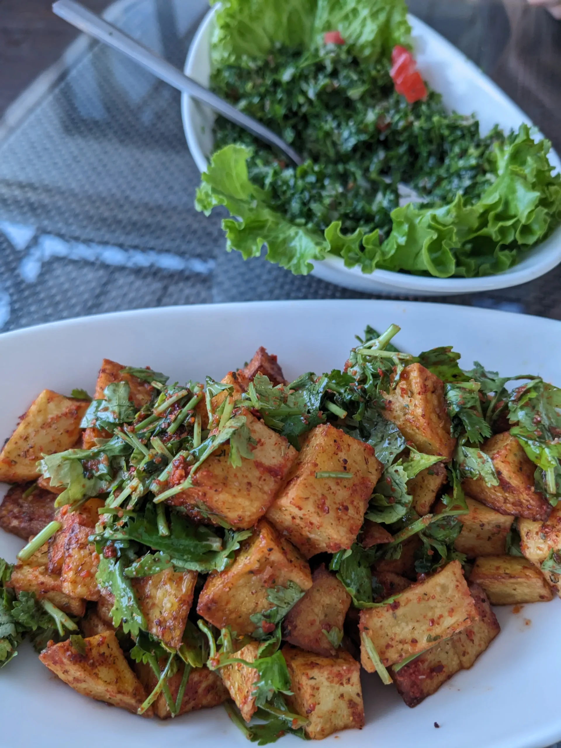 Tabbouleh and spicy potaotes a bowl of herby tabbouleh and a bowl of spiced cubes of potato at Istanbul Restaurant, Bishkek, Kyrgyzstan