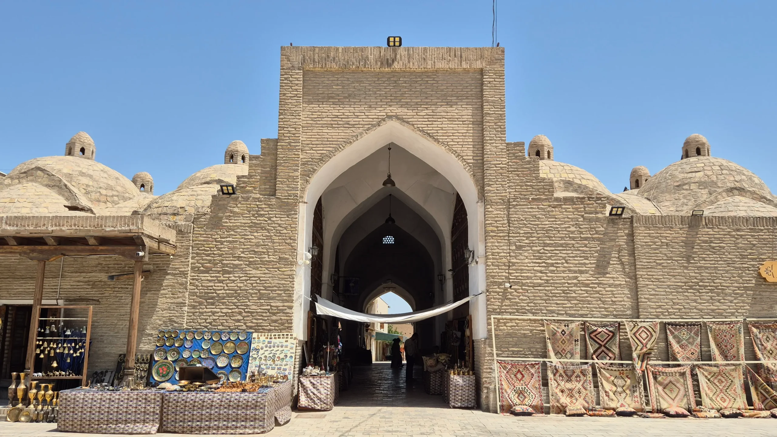 Bukhara Market a multi-domed historic, brick market place has souvenirs and carpets displayed outside in Bukhara, Uzbekistan