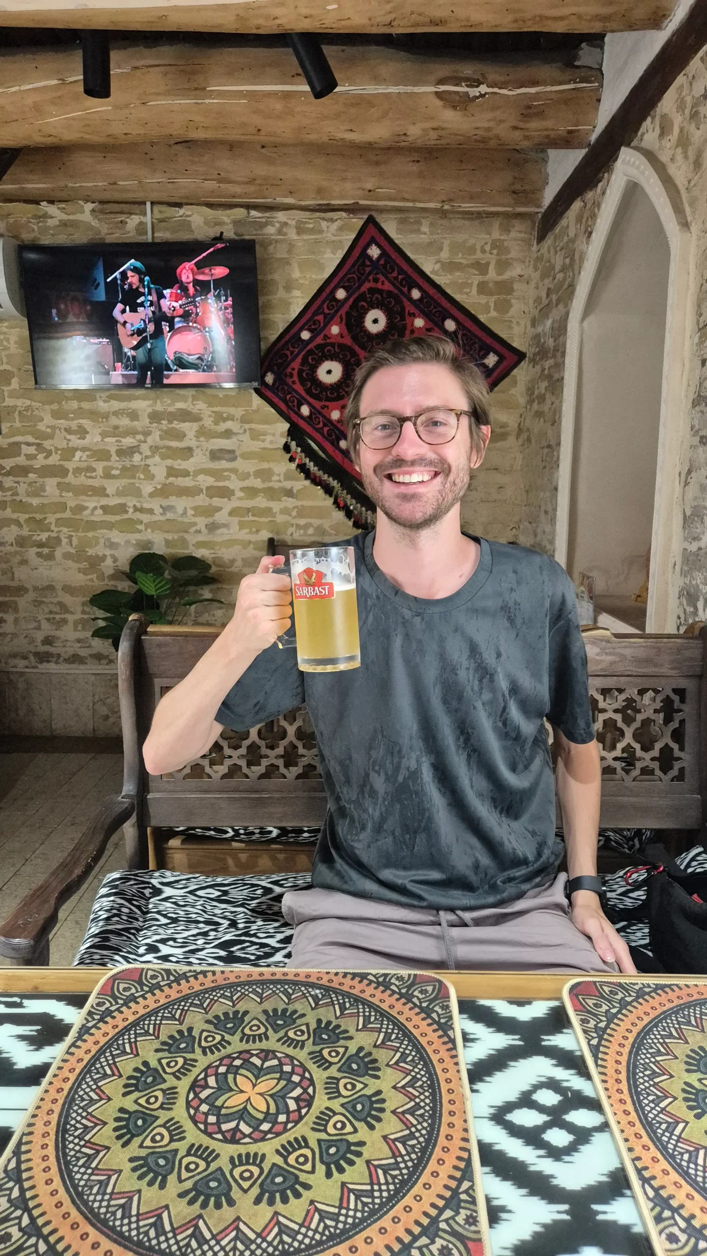 Chris & a pint of Sarbast Uzbek beer a man holds a pint of draft Sarbast Uzbek beer in an underground local bar in Bukhara Uzbekistan - Old Bar
