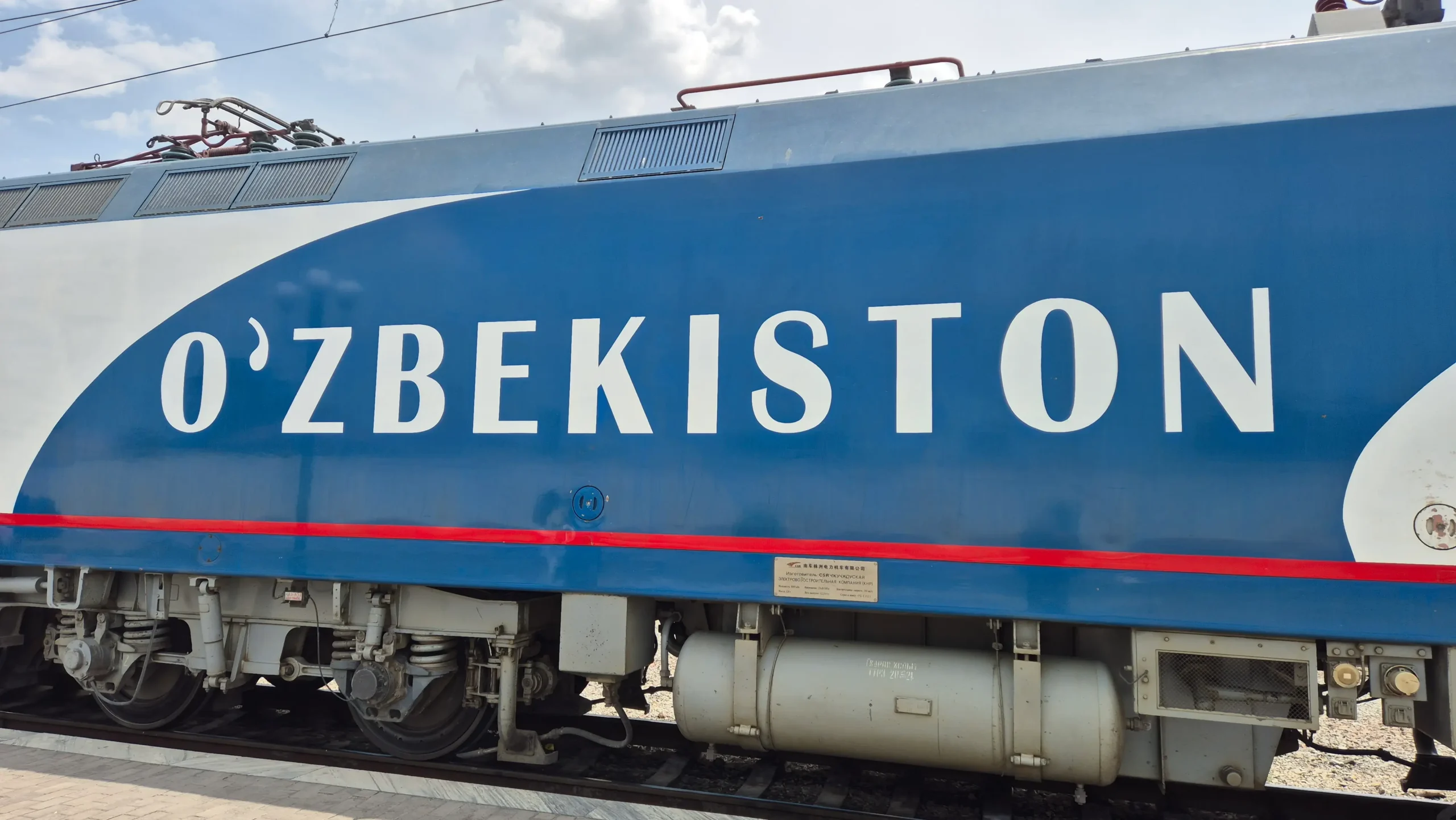 A white and blue train with Ozbekiston on the side