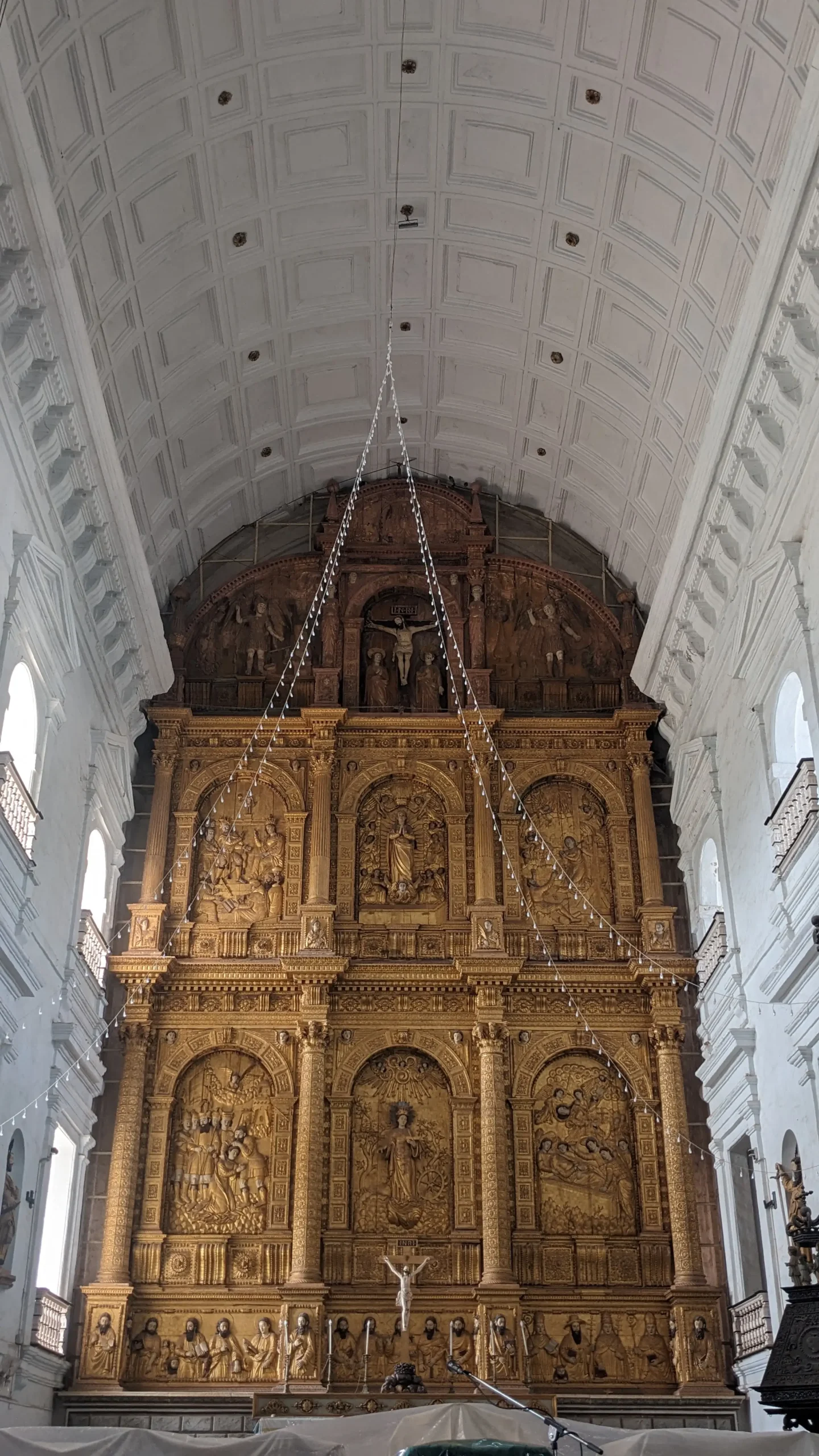 a gilded altar depicting Christian scenes and people in Se Cathedral, Old Goa