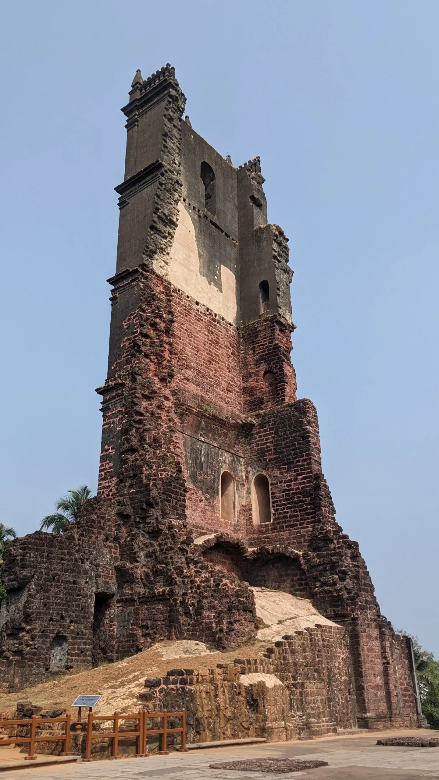 the ruins of a cathedral tower show red and black bricks. Only half of the tower remains - St Augustine, Old Goa, India