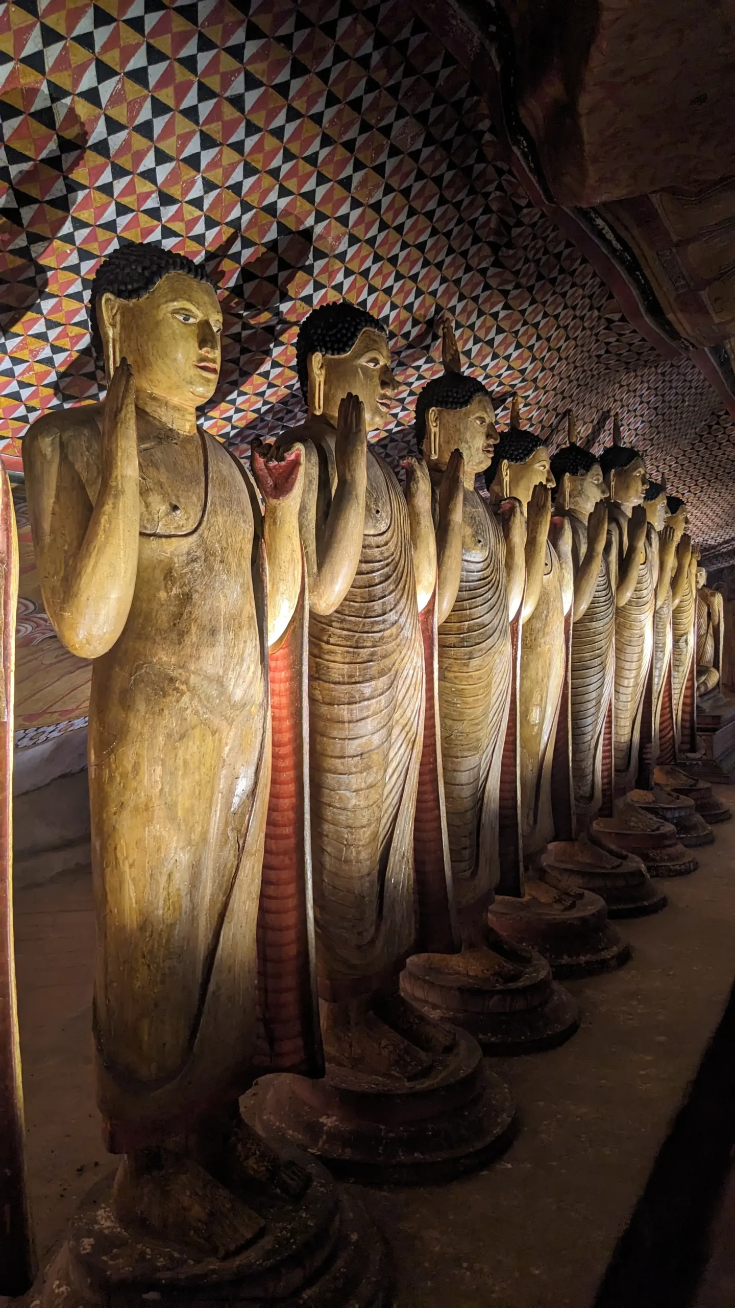 Buddha Statue at Dambulla Caves a row of life-size Buddha statues stand inside the Dambulla Caves. Travel tips for Sri Lanka
