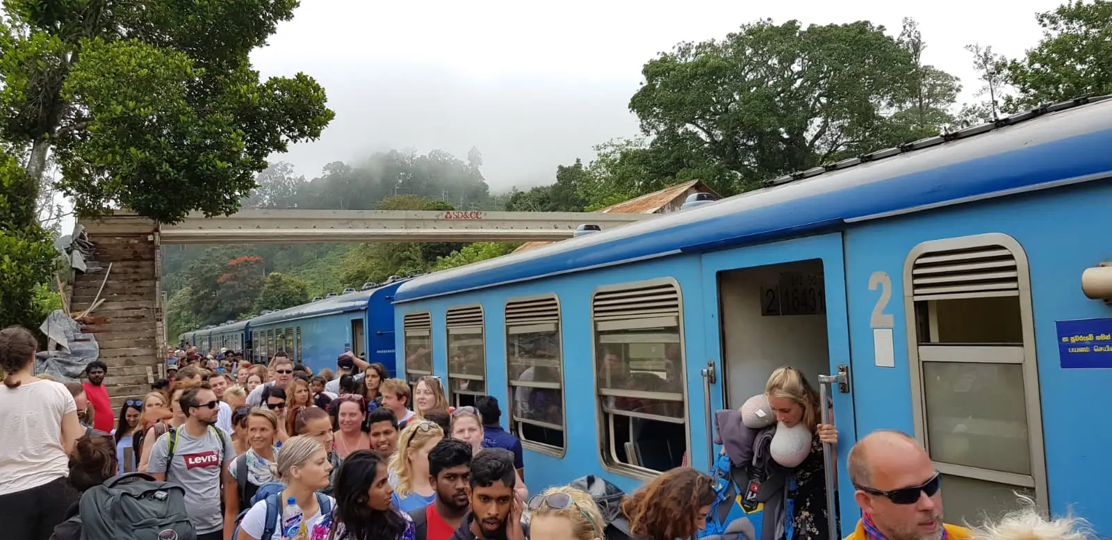 Crowds of tourists getting off the train crowds of tourists are getting off the blue Kandy to Ella train at Ella train station surrounded by rainforest in Sri Lanka