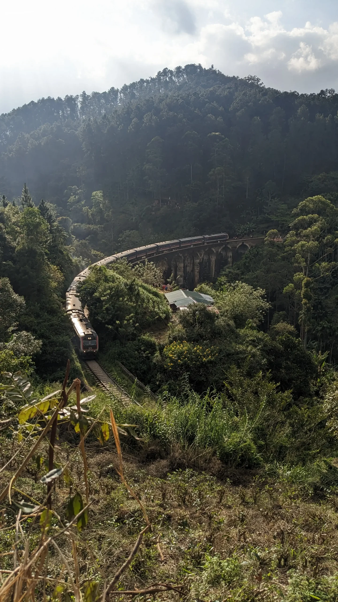 train crossing the Nine Arch bridge a train crosses the famous brick Nine-Arch bridge in Ella, Sri Lanka surrounded by lush, green, rainforests. Kandy to Ella train