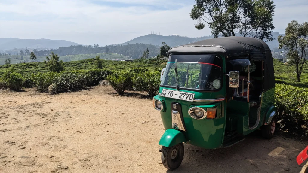 Sri Lanka Travel Guide 9 a green tuktuk is parked at the edge of a tea plantation in Nuwara Eliya, Sri Lanka travel guide