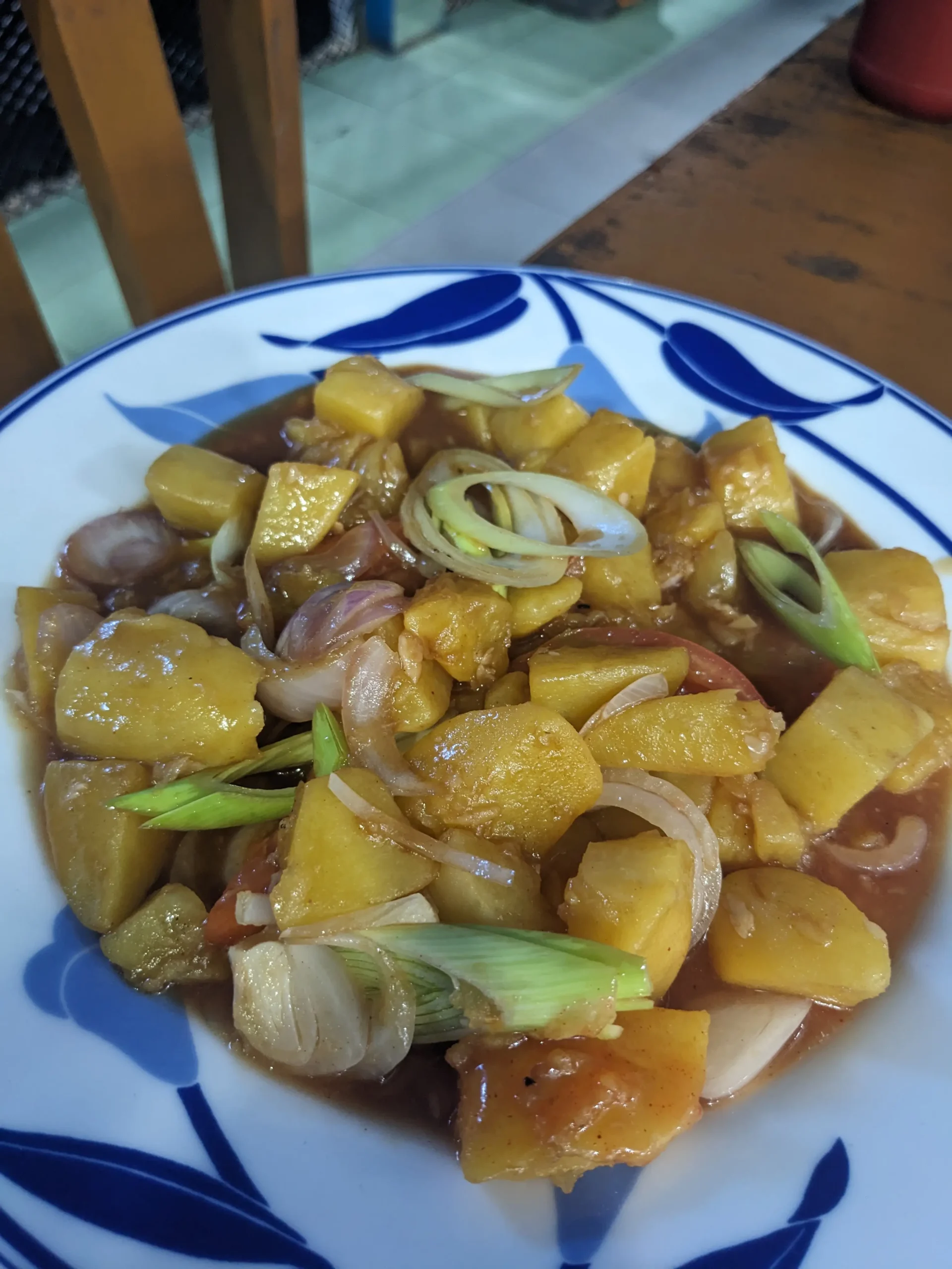 cubes of potato with slices of spring onions in a sticky orange sauce - Sri Lankan devilled potatoes