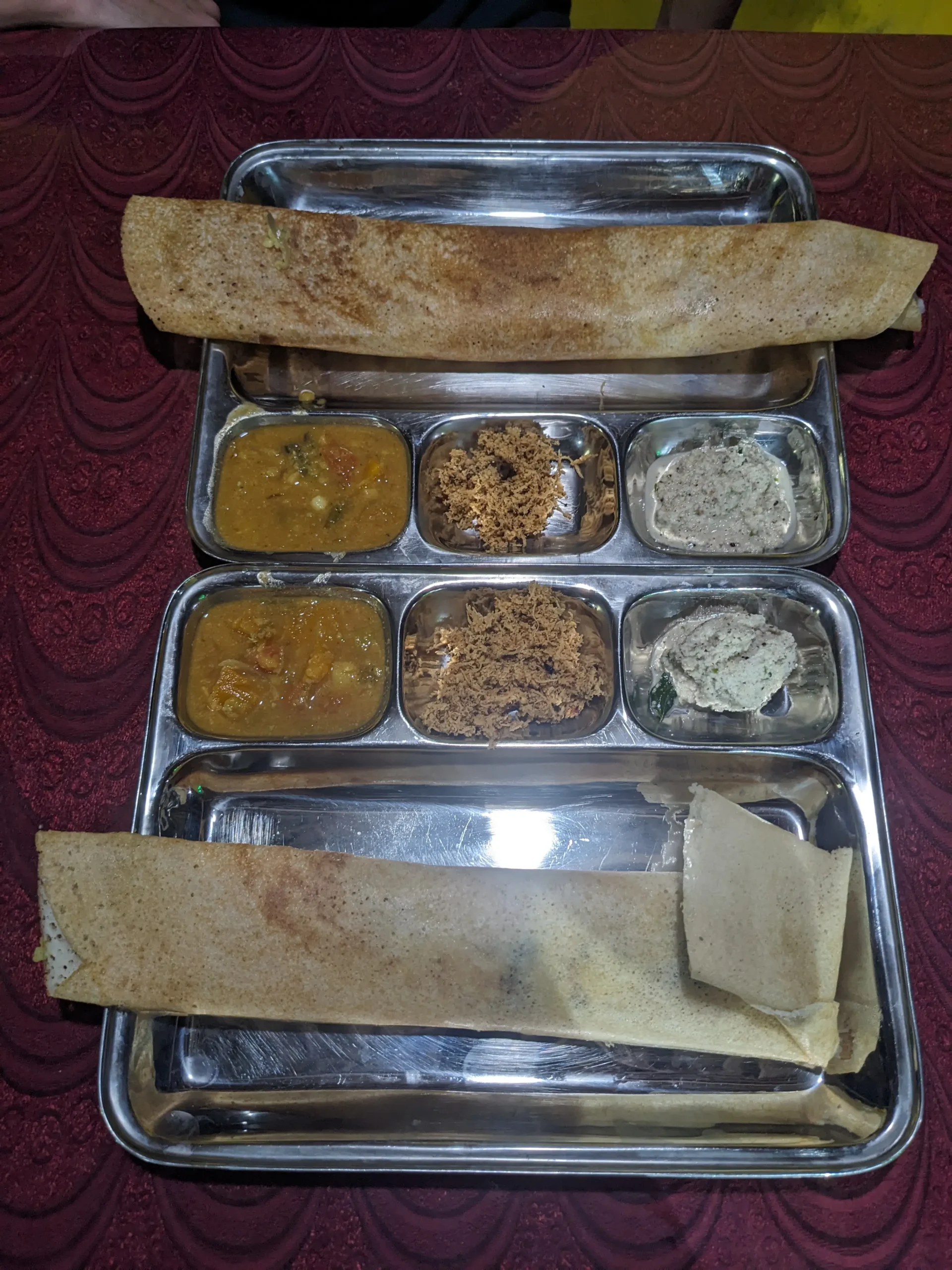 two metal trays each with a Sri Lankan dosa, chutneys and sambar