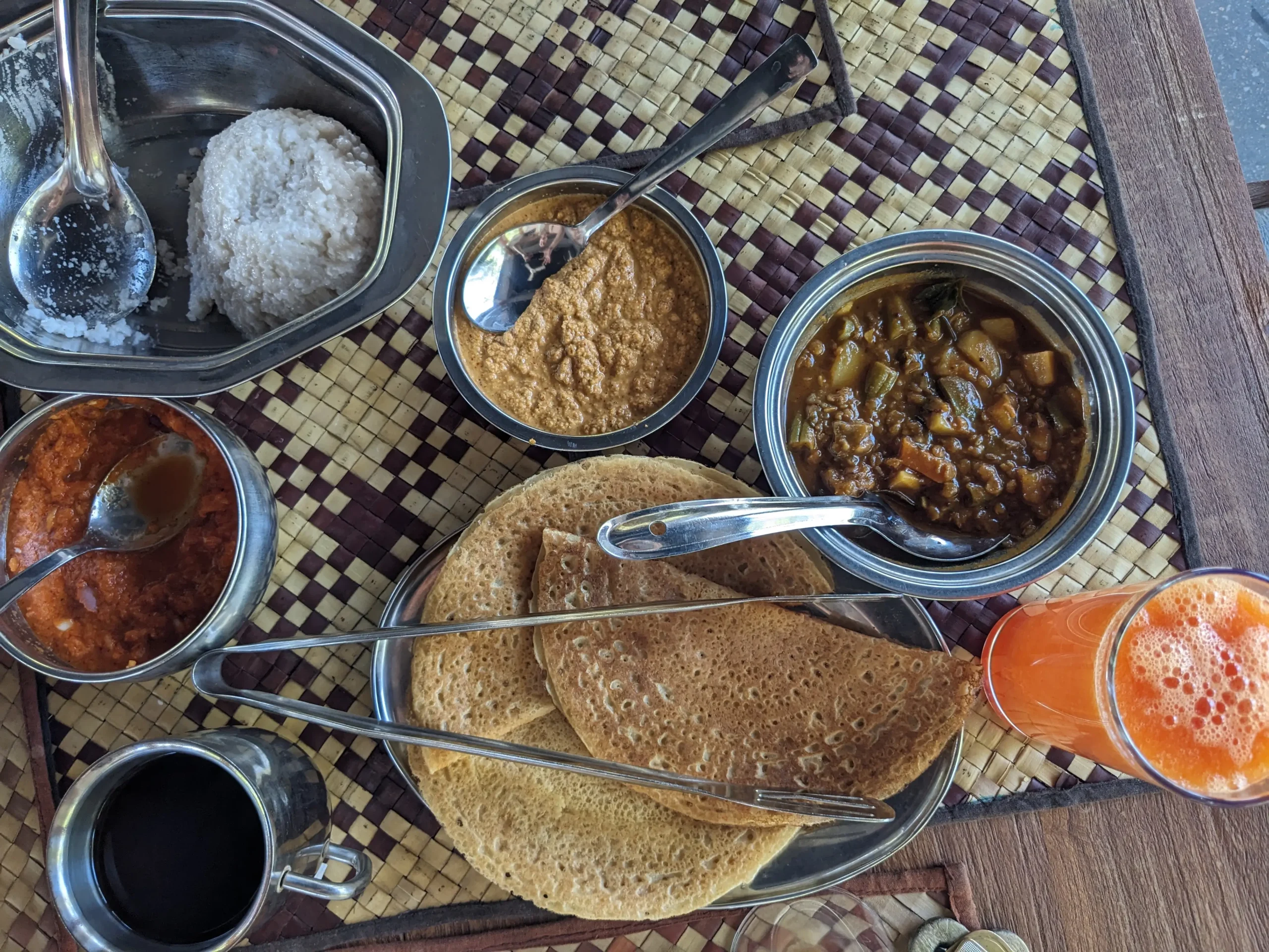 a spread of various chutneys, dosa, papaya juice, coffee and Sri Lankan kiribath (milk rice)