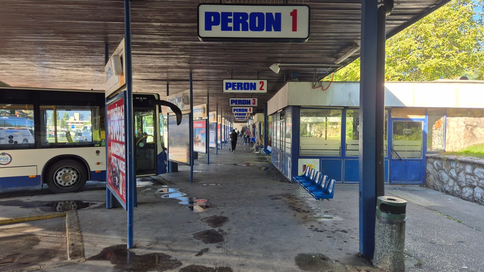 a look through Sarajevo bus station shows a parked bus, blue plastic seats, and all the platform signs. Bosnia and Herzegovina