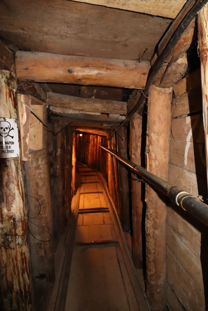 a look inside the Tunnel of Hope underneath Sarajevo airport has wooden floor, walls and ceiling, plus wooden pillar supports.