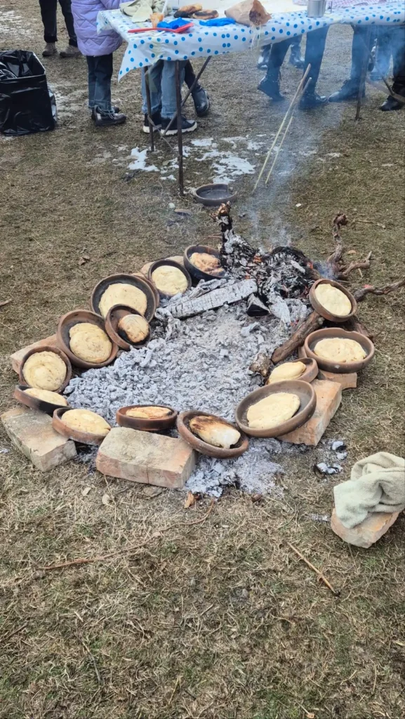 Georgian kada bread being backed in a earthenware pots over hot embers at Berikaoba 