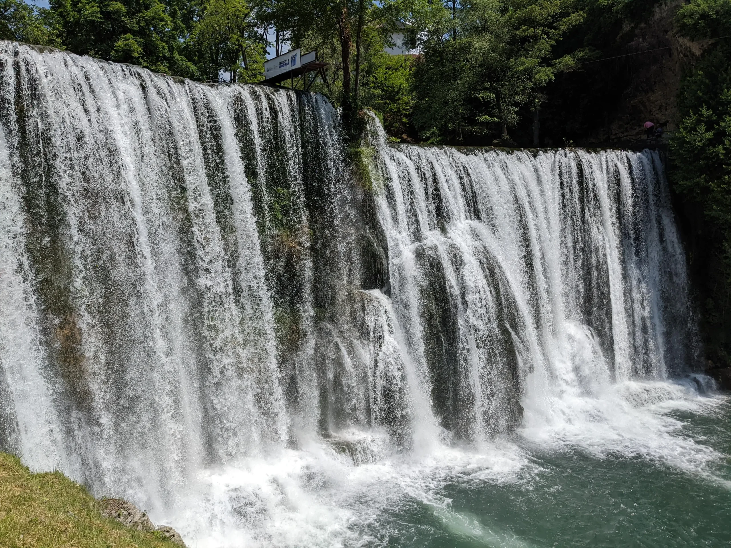 a tall and wide waterfall cascades down to a plunge pool - Pliva Waterfall in Jajce, Bosnia and Herzegovina