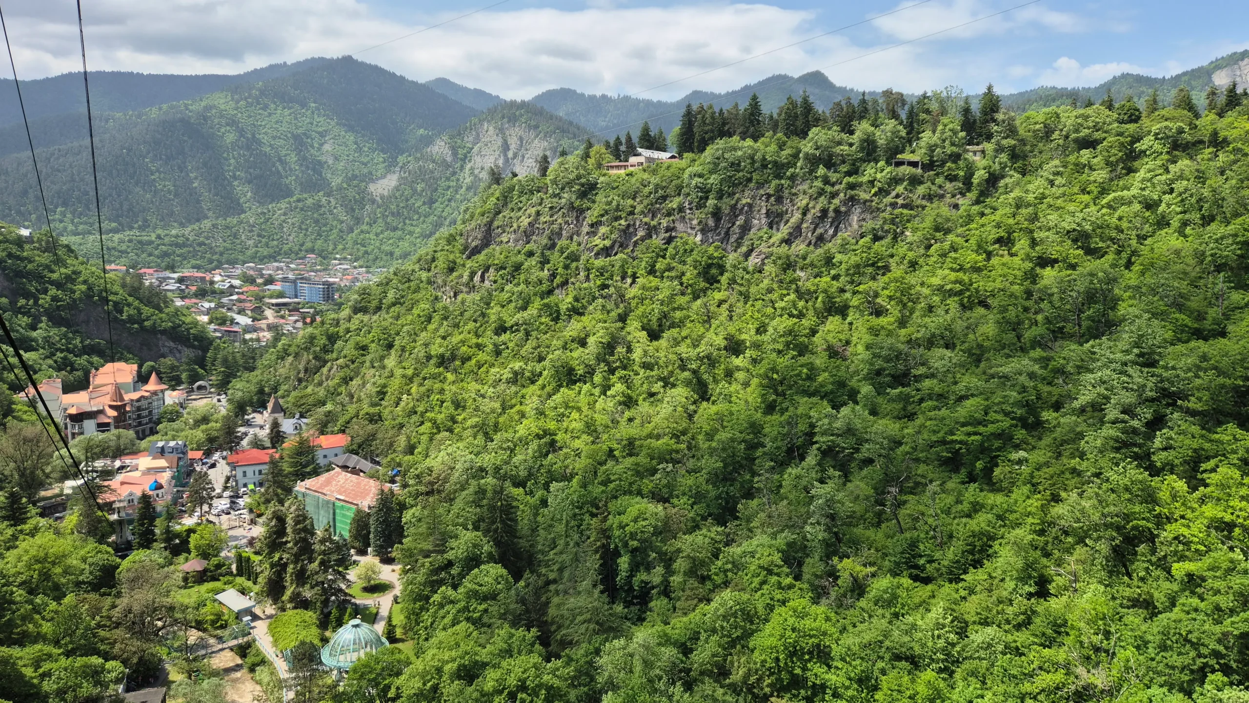 a view above Borjomi in Georgia of rolling green hills and a small colourful town