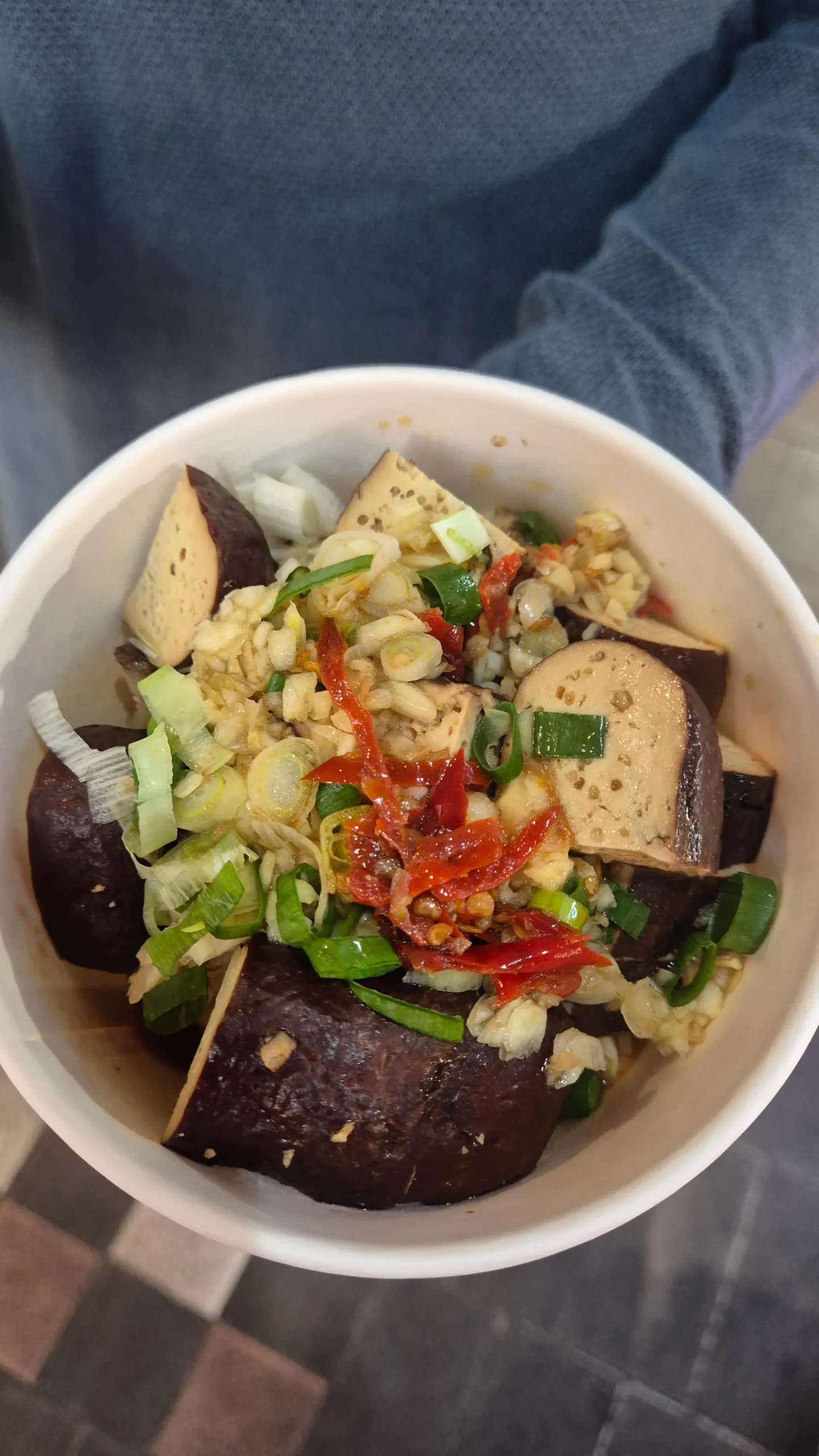 a tub of braised tofu chunks topped with fresh garlic, chilli and spring onions - Taiwanese street food