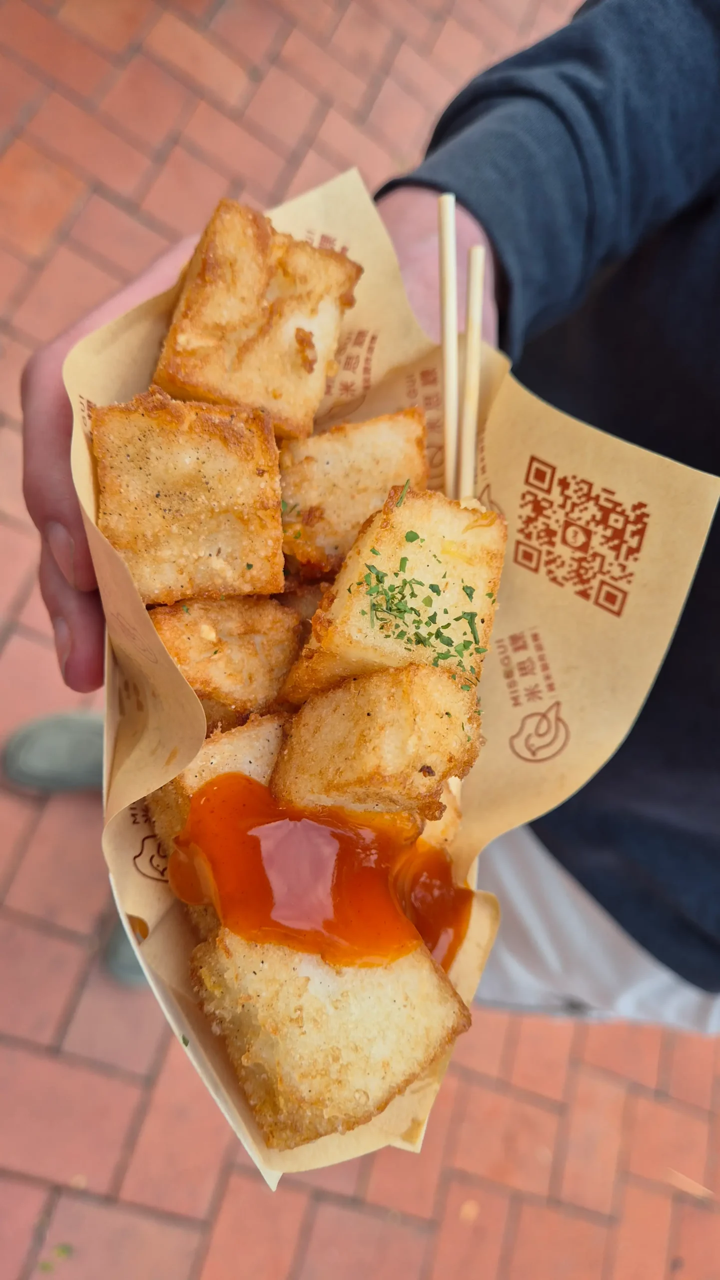crisp cubes of Taiwanese radish cake sit on brown paper at a night market