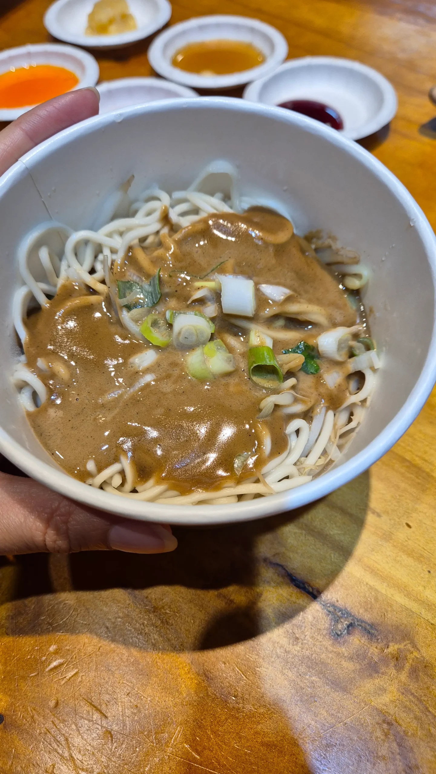a cowl of noodles topped with a creamy sesame paste sauce and spring onions in Taiwan