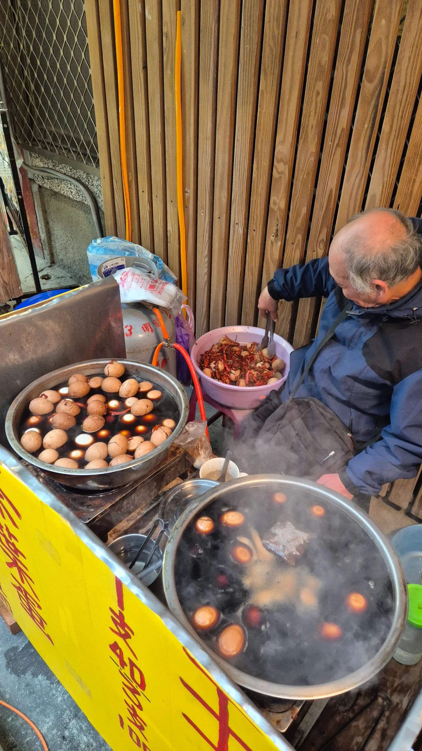 a street vendor has two large pots full of a dark marinade and hard boiled eggs - tea eggs in Taiwan