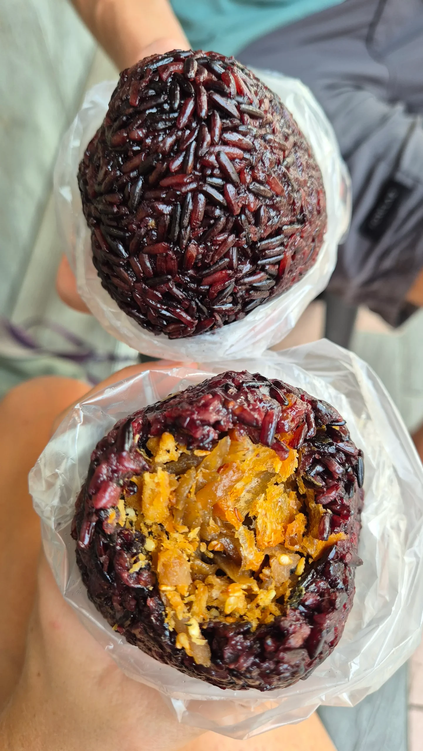 a Taiwanese rice ball has bright purple rice surrounding a filling of crispy youtiao doughnuts, sesame seeds and pickled radish