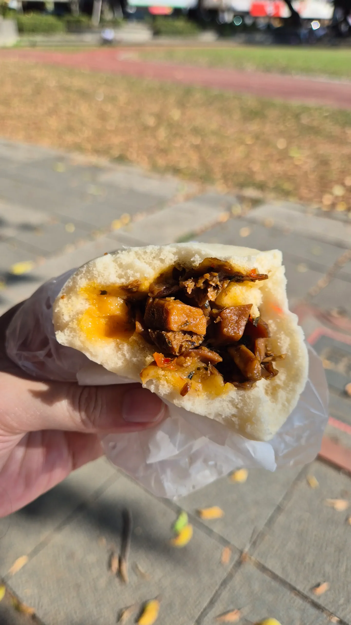 the cross-section of a Taiwanese steamed bun has a soft spongy dough filled with mushrooms, chilli, and filling