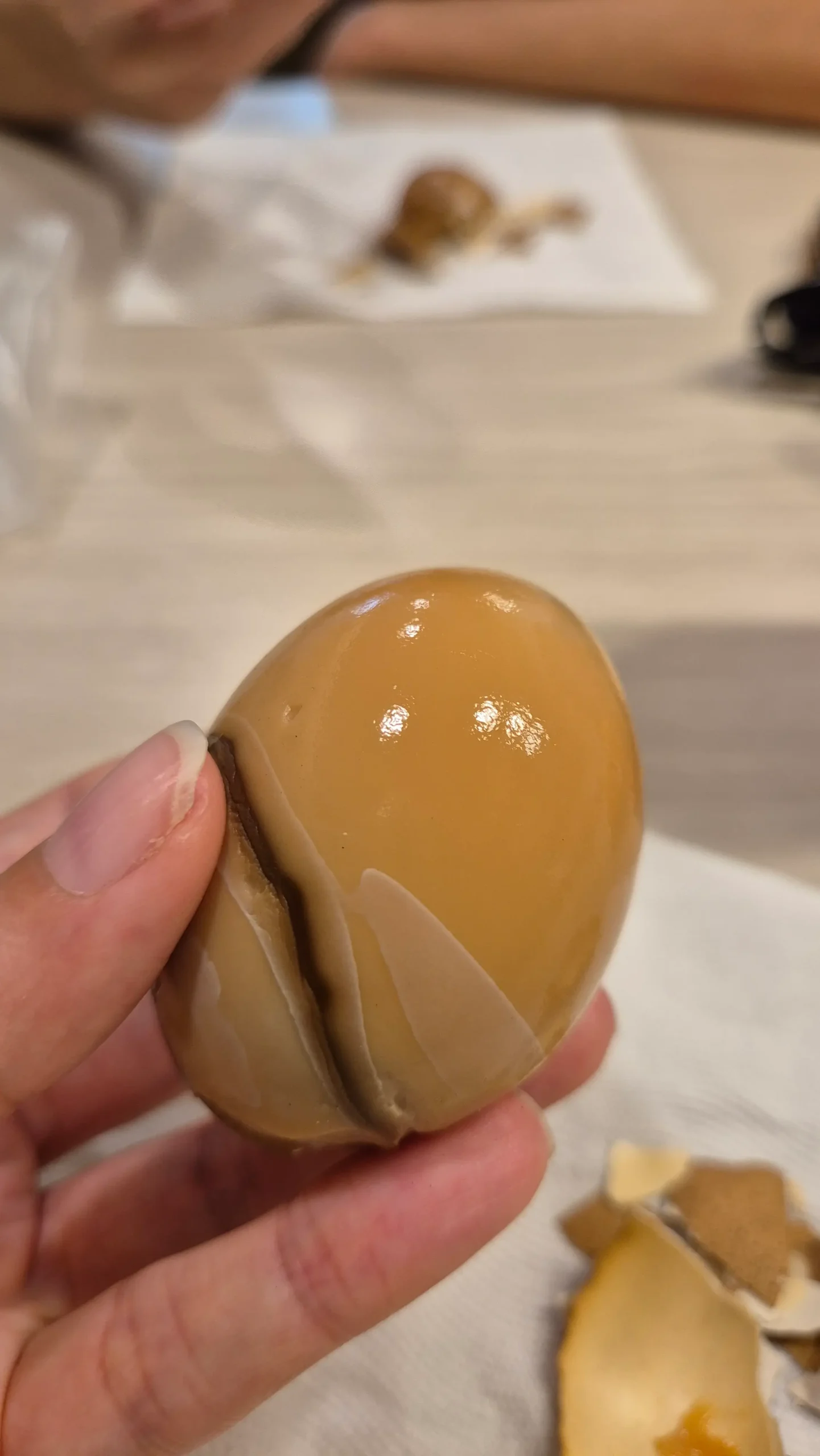 a peeled hard-boiled tea egg has a light brown egg white and dark marbling - Taiwanese street food 