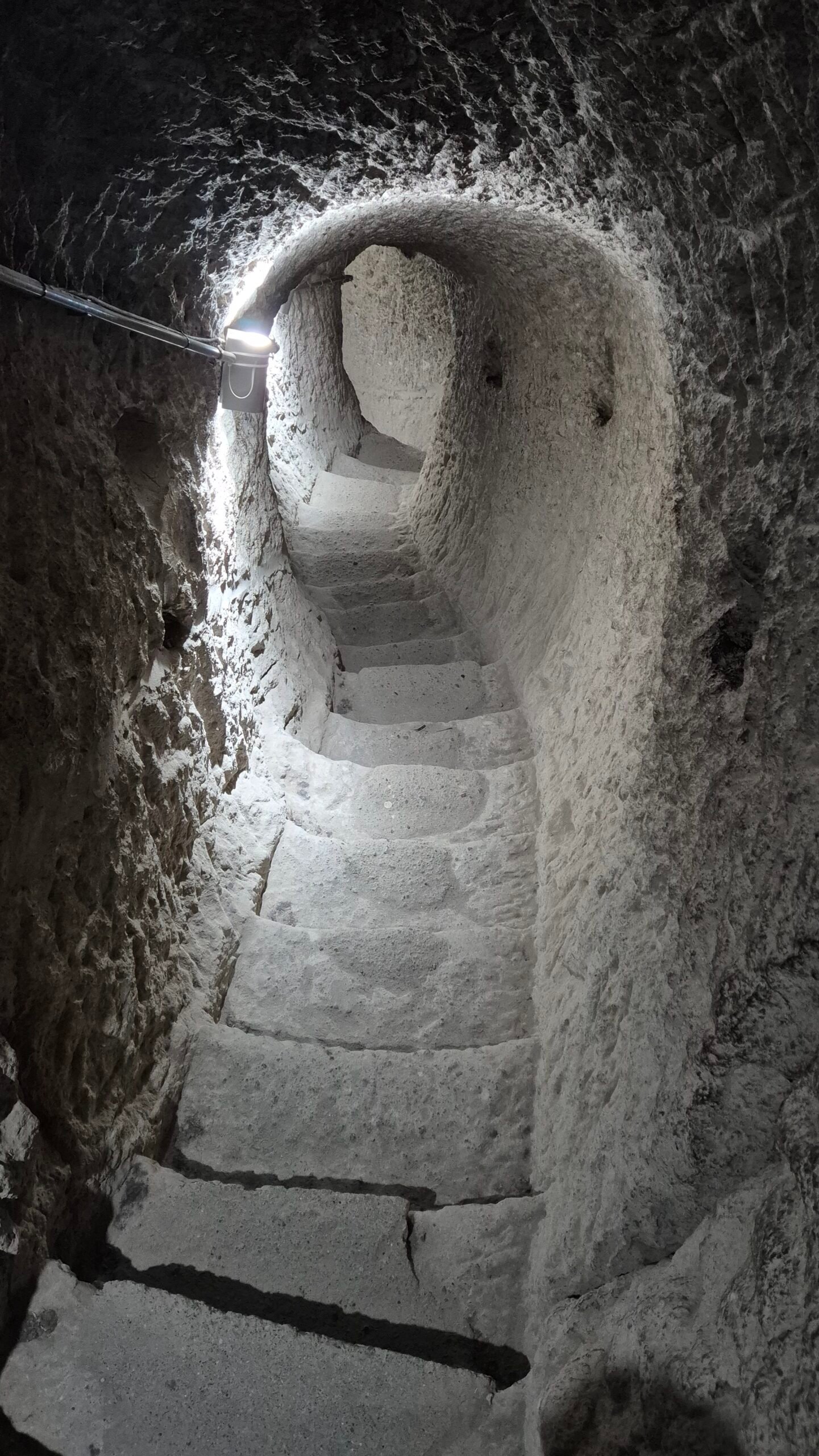 a tunnel with steps carved into the rock of Vardzia cave city in Georgia