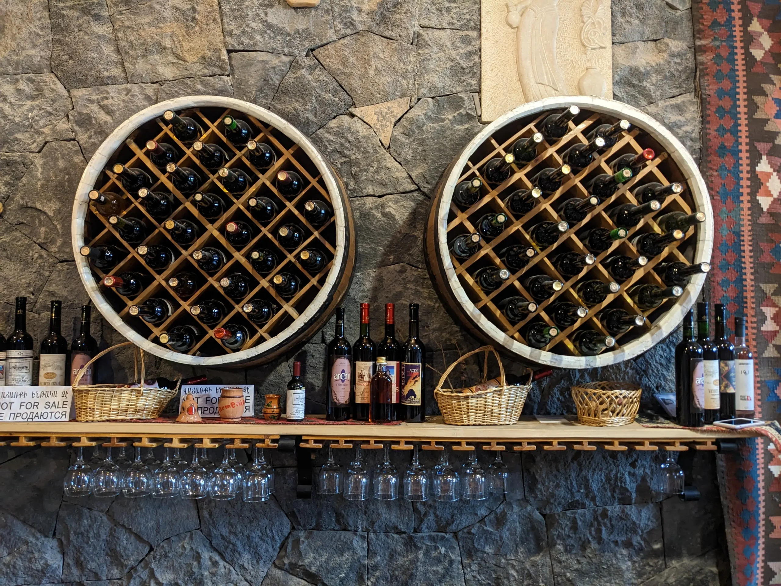 many bottles of wine and wine glasses on display at a wine tasting in Armenia's wine region - Areni