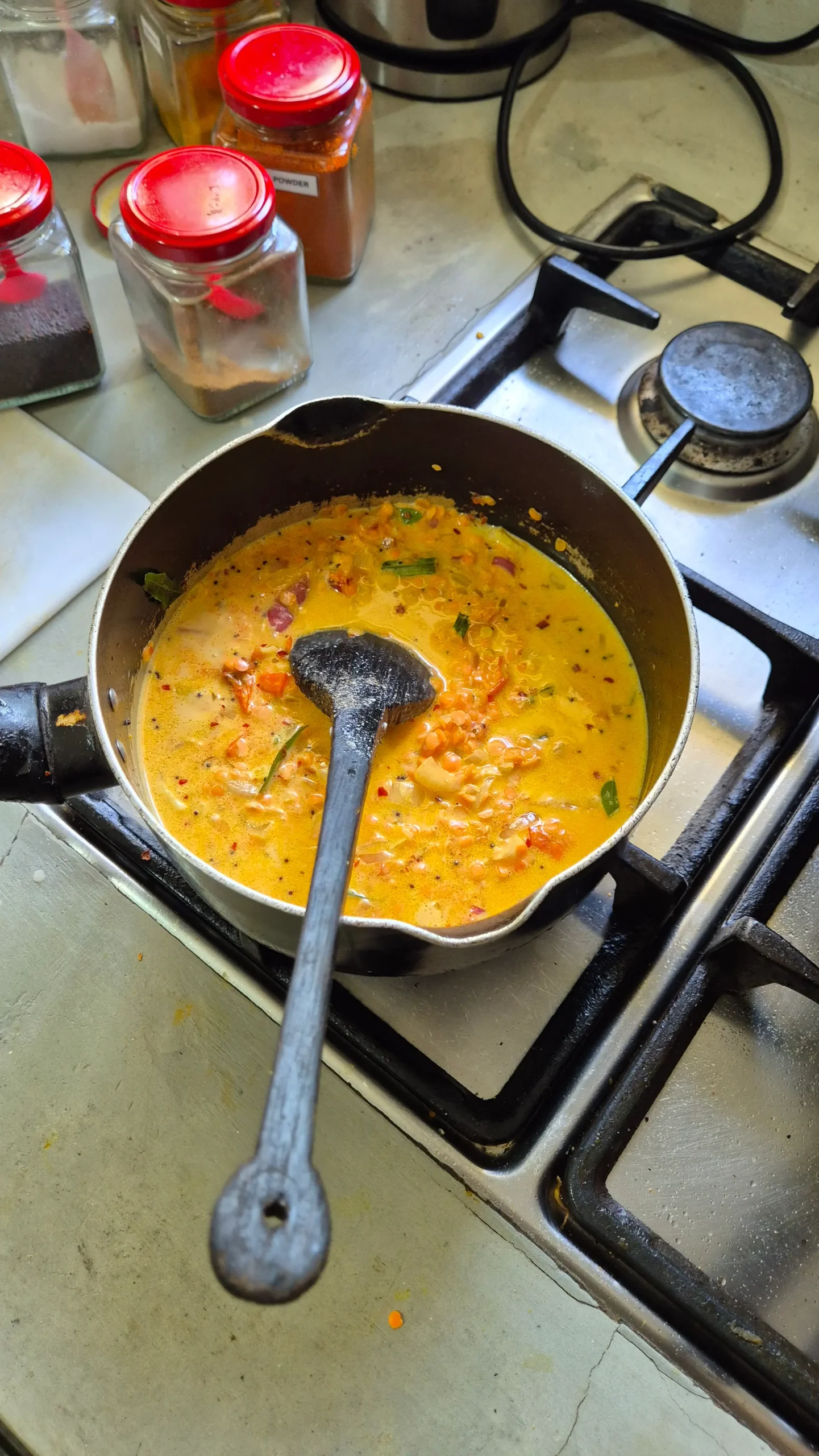 the dal! a saucepan filled with a bright yellow creamy Sri Lankan dal curry