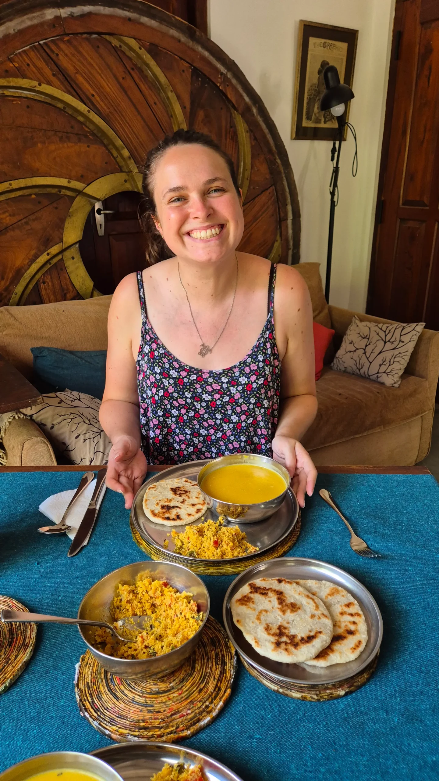 Sam with the magic pumpkin soup a woman has a metal plate of Sri Lankan coconut roti, coconut sambol, and spiced pumpkin soup