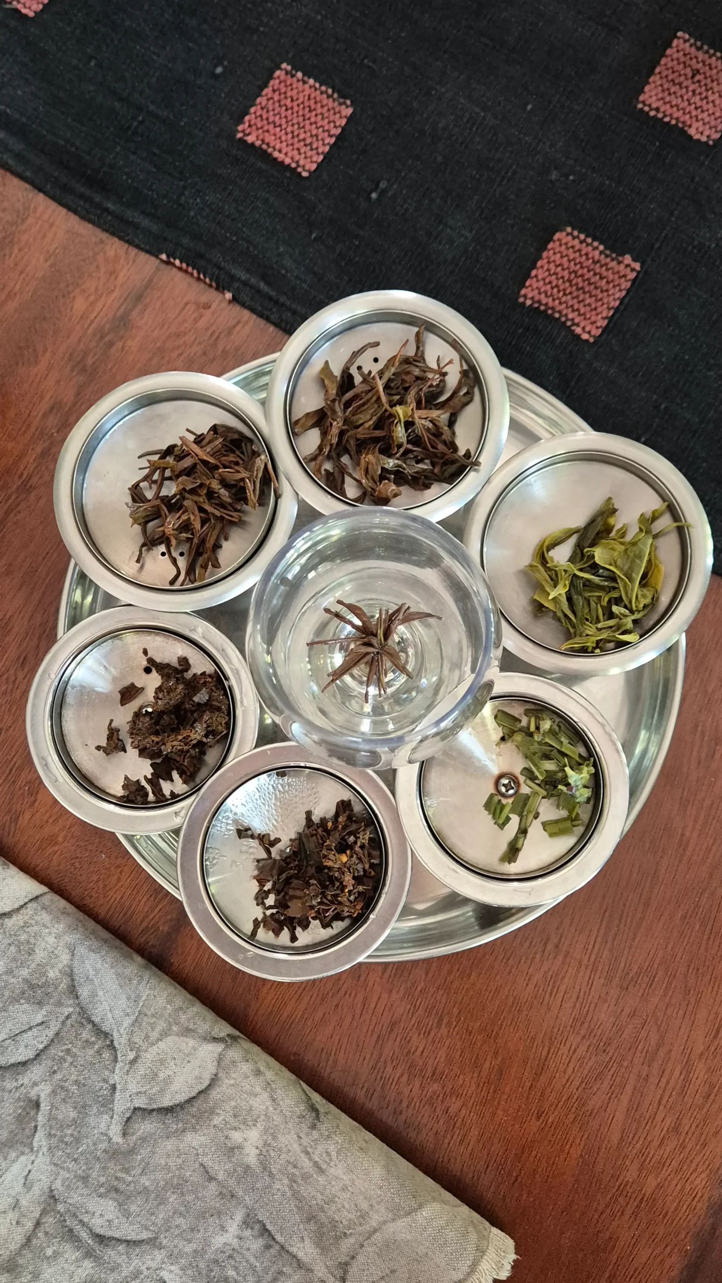tea leaves six containers in a circle each have different Sri Lankan tea leaves in them