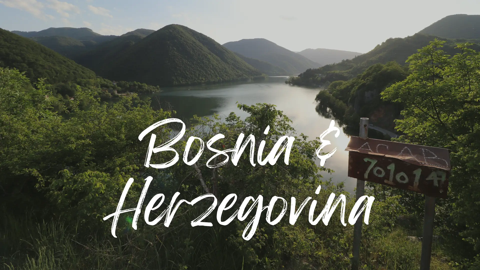 the large dark waters of Pliva Lakes near Jajce are surrounded by hills covered int greenery. Bosnia and Herzegovina travel guide