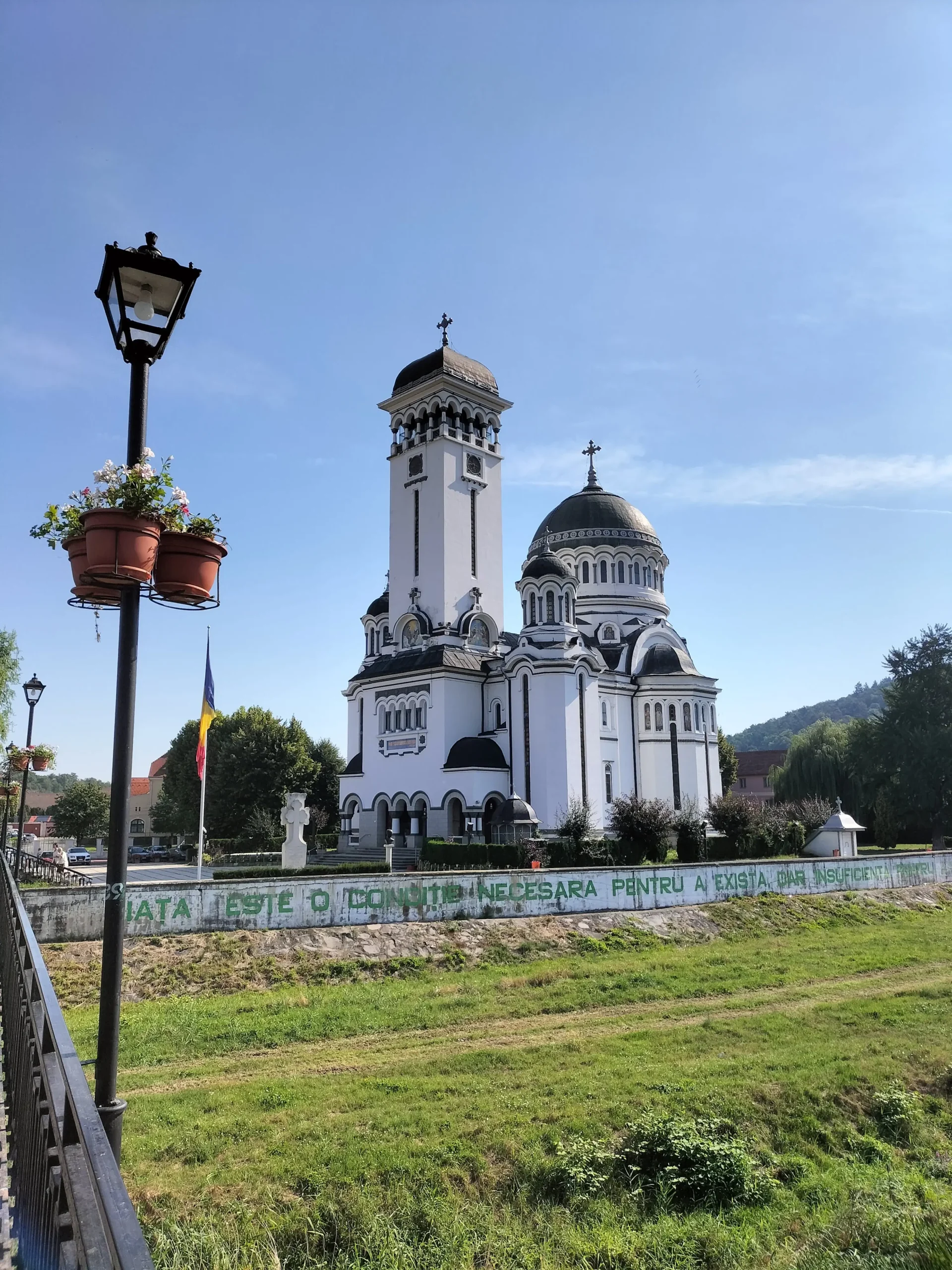 Holy Trinity Church (Biserica Sfânta Treime) in Sighisoara, Romania, has white cylindrical towers topped with round black domes and crosses on the top