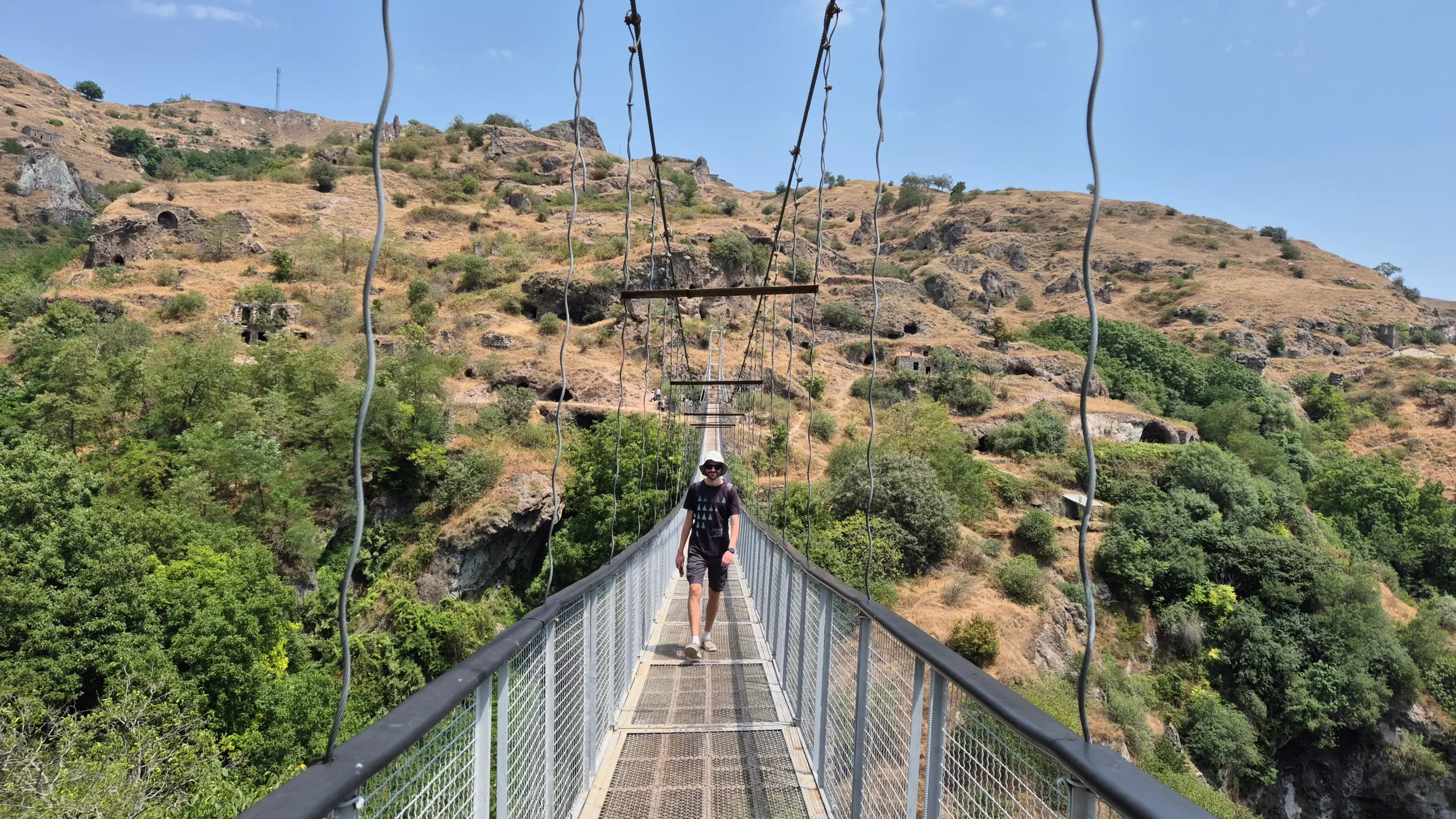 Khndzoresk Swinging Bridge a man walks across a swinging bridge over a valley in Khndzoresk, Armenia